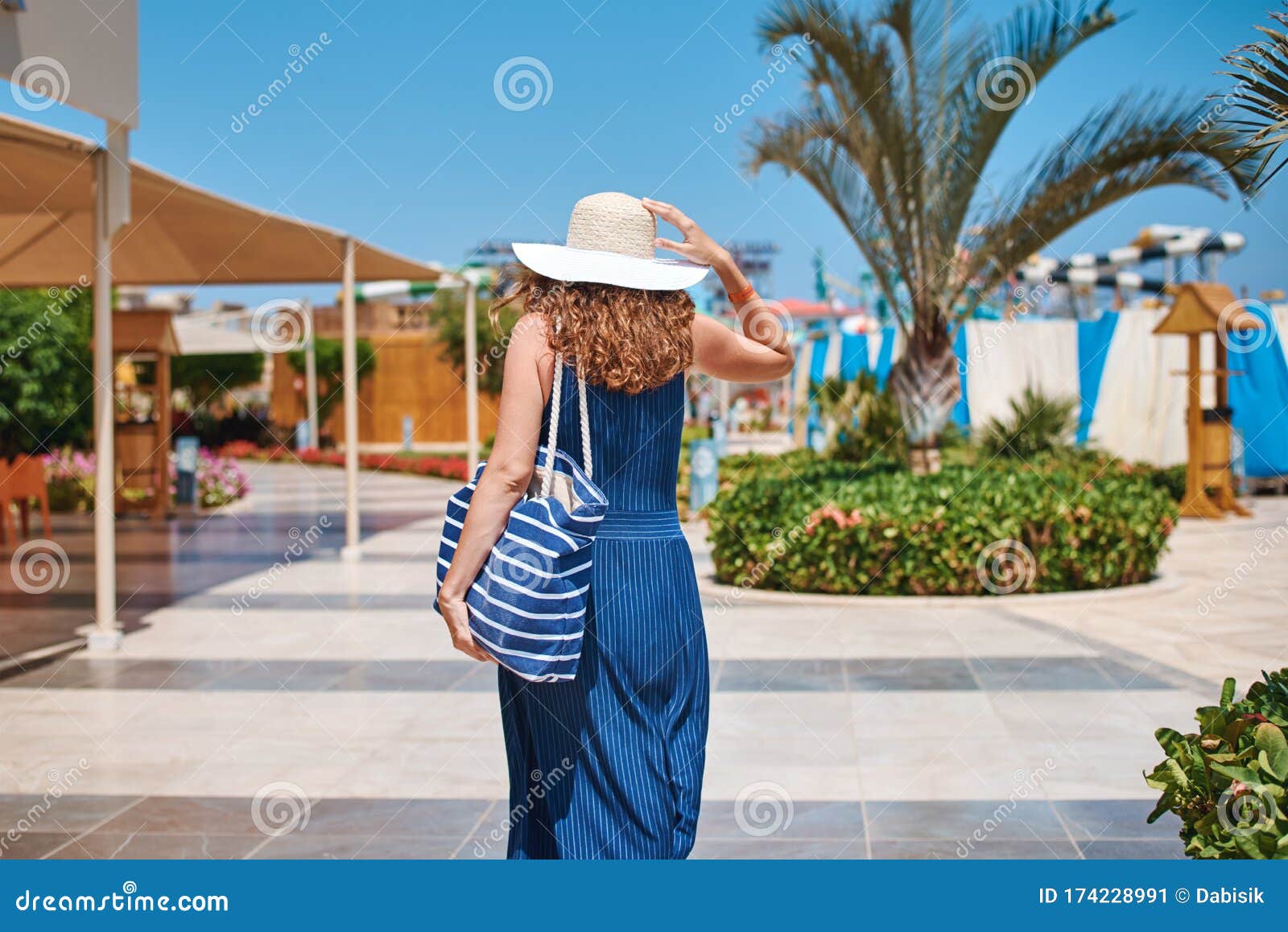 Mujer Con Sombrero Y Vestido Azul Ir a Dar Un Paseo En El Hotel Resort  Cerca De La Piscina Con Bolsa De Playa Imagen de archivo - Imagen de  libertad, azul: 174228991