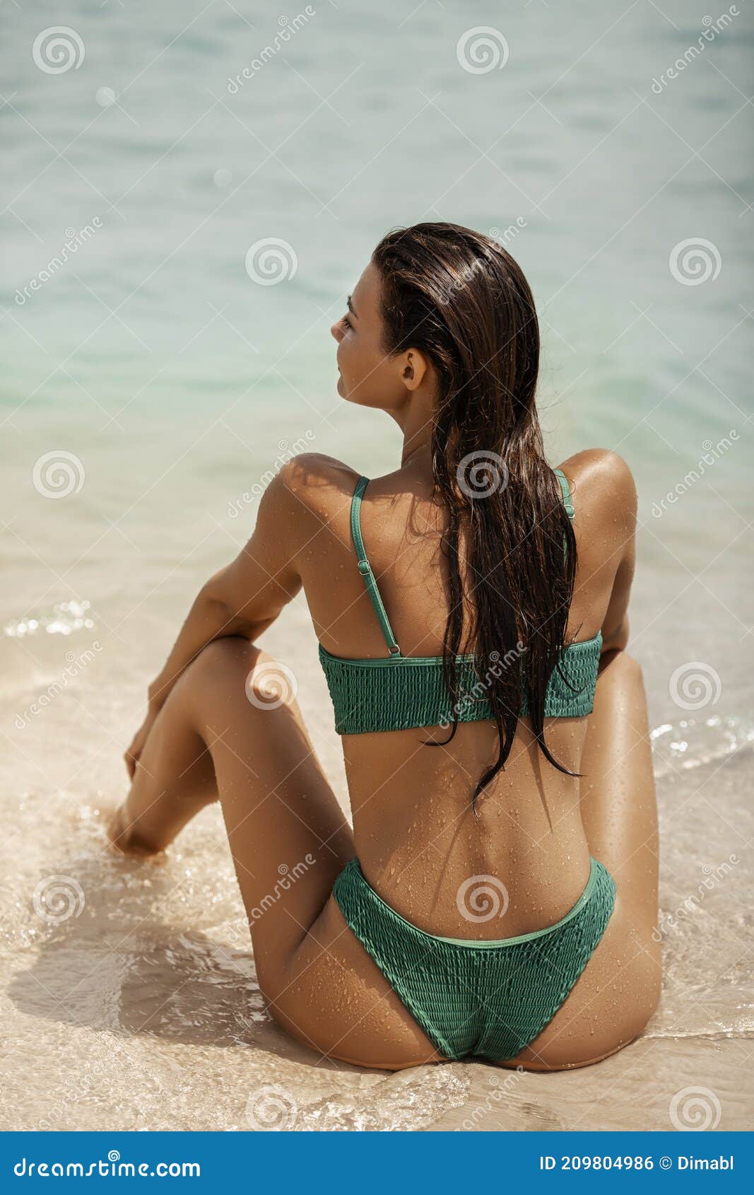 Hermosa mujer en forma en ropa de playa de moda admirando el