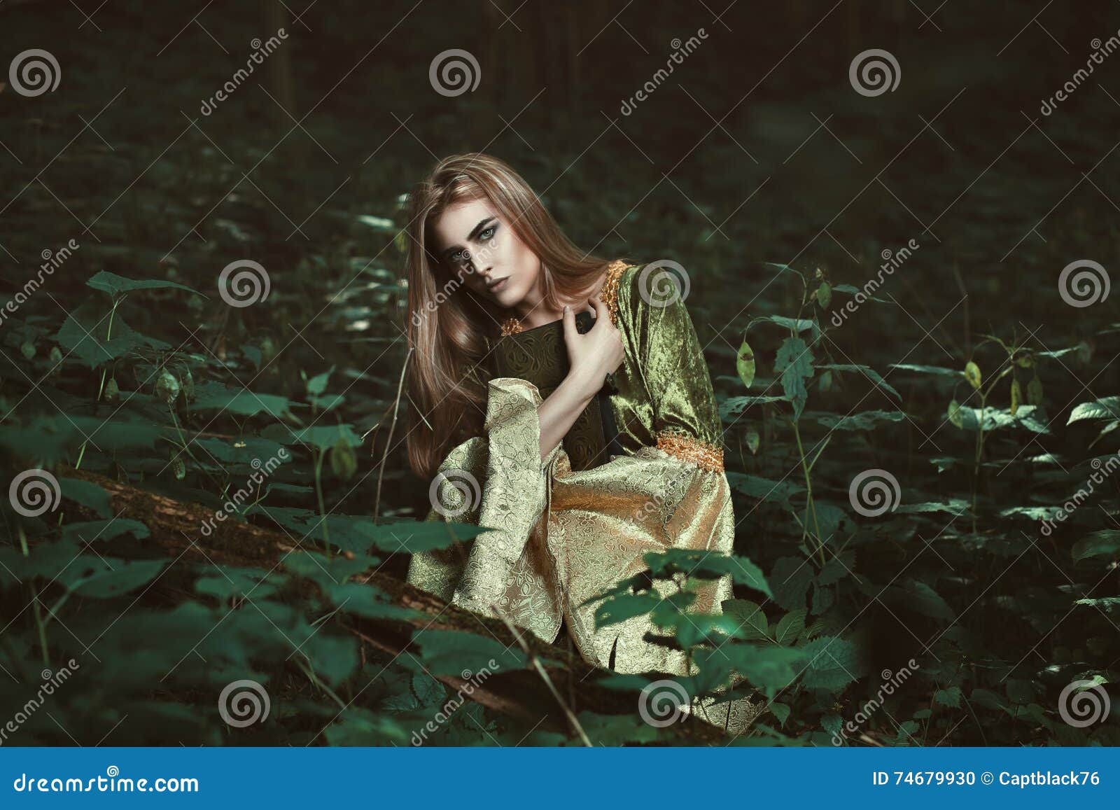 Mujer de hadas con un libro en el bosque. Mujer de hadas con un libro mágico en un tiro oscuro de la fantasía del bosque