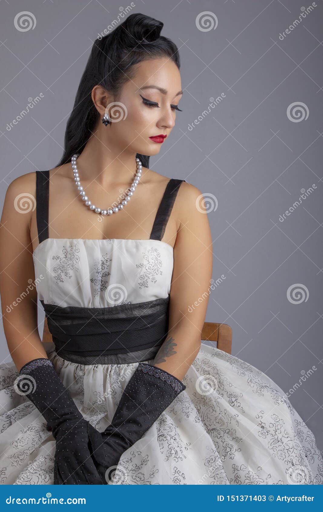 Mujer De Los Años 50 En El Vestido Blanco Y Negro Que Se Sienta En Una Silla Imagen de archivo - Imagen de aguja, contexto: