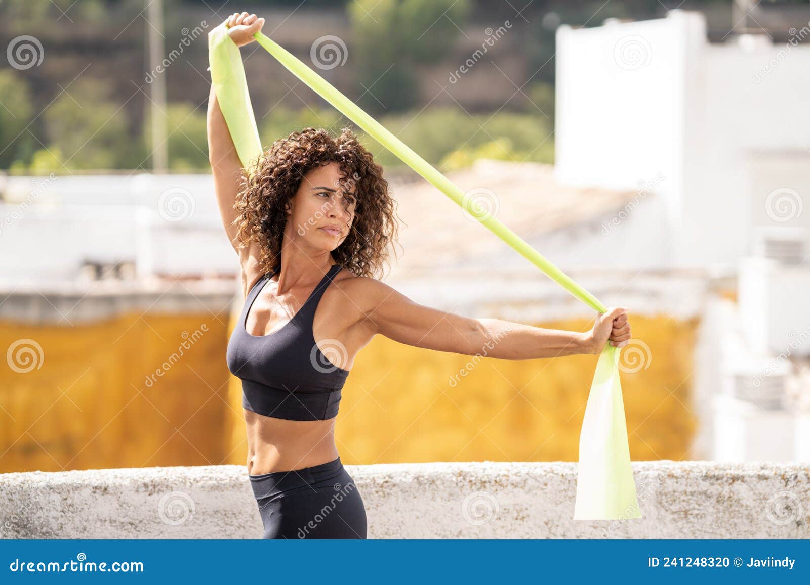 Mujer de mediana edad con cuerpo fitness trabajando en la terraza