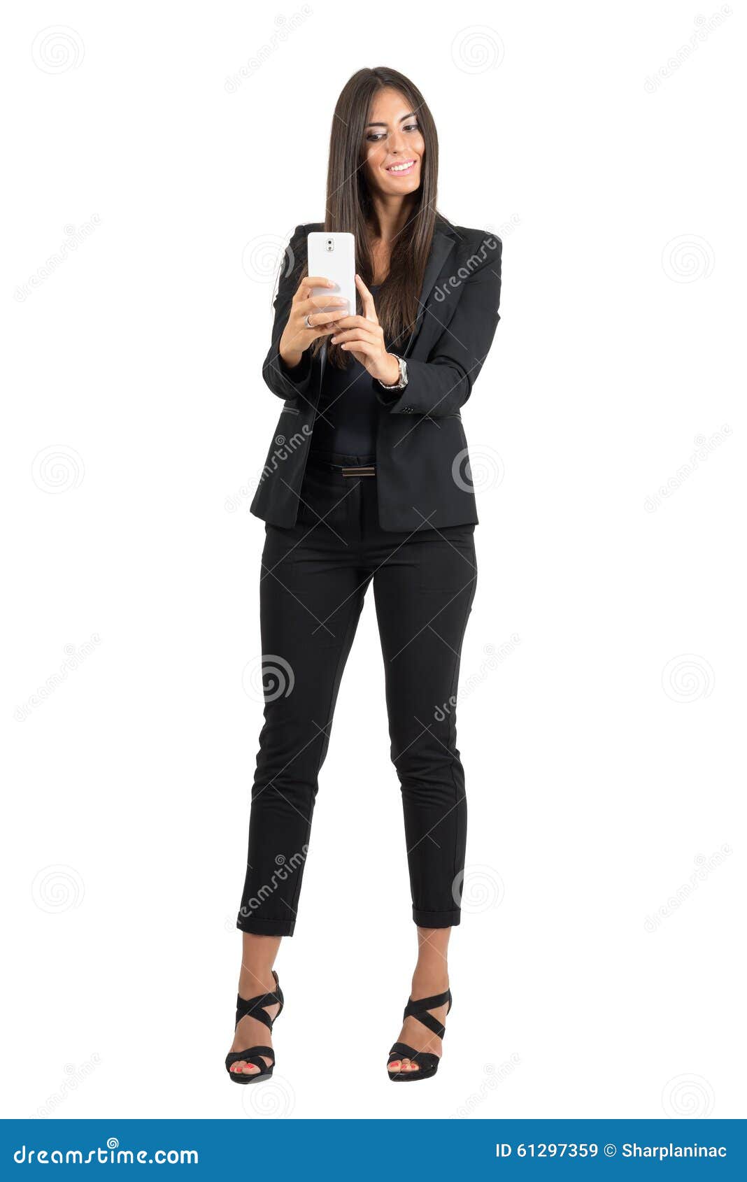 Mujer de negocios feliz en el traje negro que toma la foto con el teléfono móvil Retrato lleno de la longitud corporal aislado sobre el fondo blanco del estudio