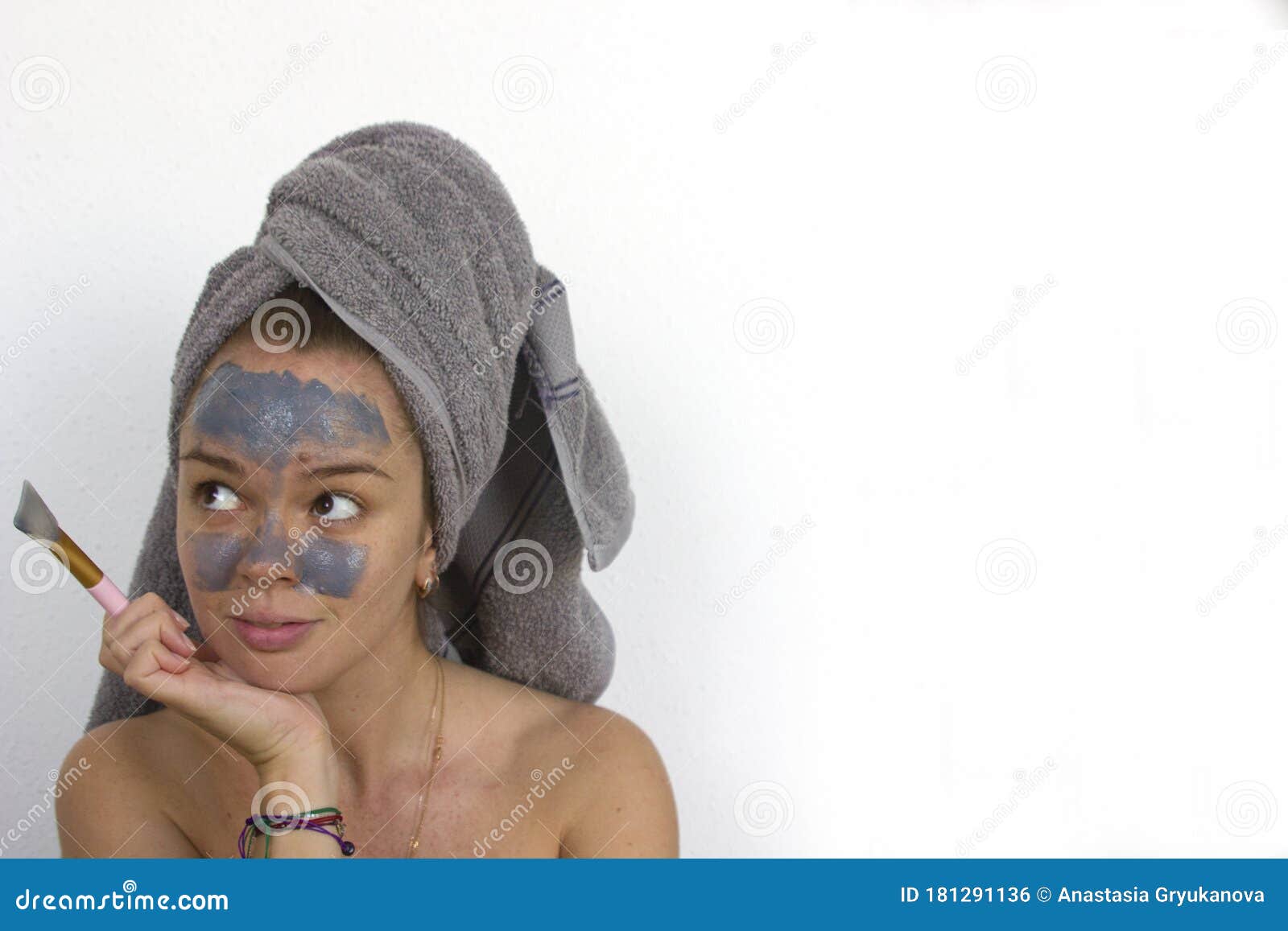 Mujer con toalla en la cabeza saliendo de la ducha con un reloj Fotografía  de stock - Alamy