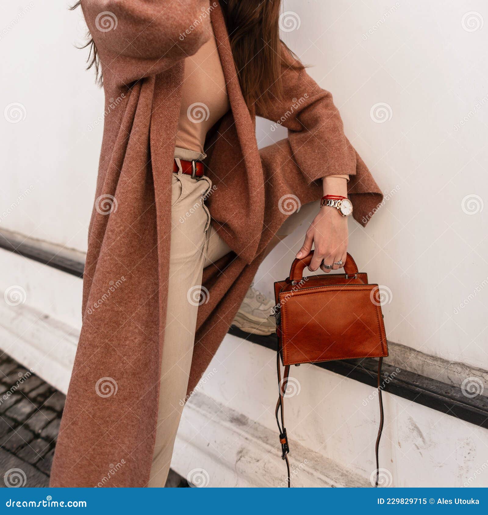 Elegante mujer con pantalón beige y abrigo