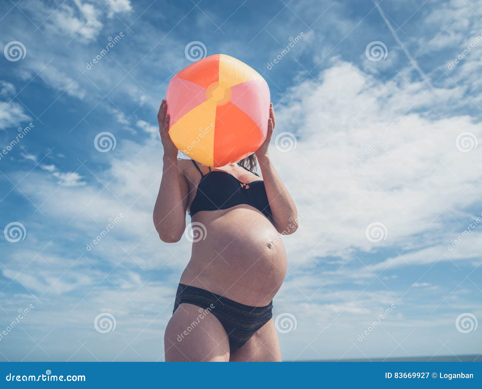 Mujer Embarazada De Los Jóvenes Con La Pelota De Playa Imagen de archivo -  Imagen de exterior, expectante: 83669927