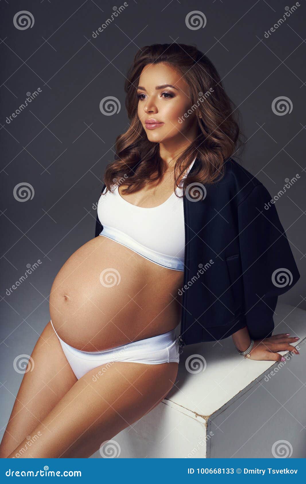 Mujer Embarazada En La Ropa Interior De Los Deportes Que Se Sienta