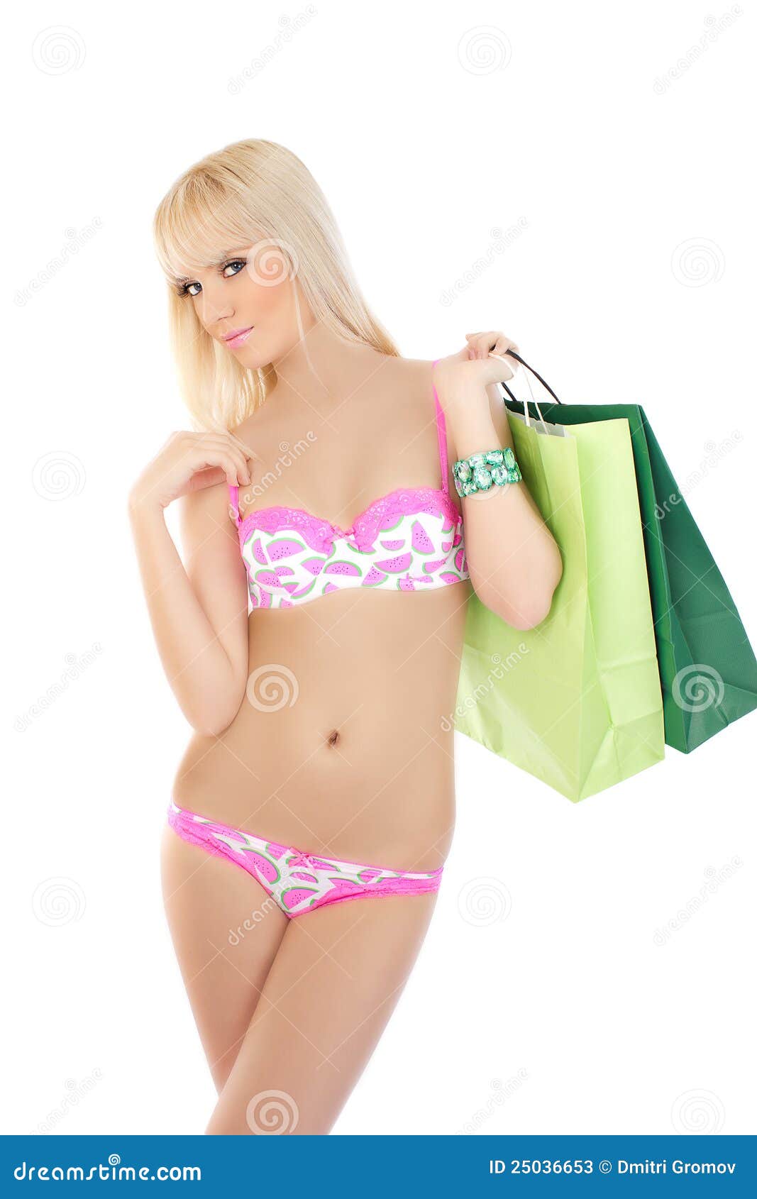 Mujer en bolsos de compras rosados de la explotación agrícola de la ropa interior. Mujer joven hermosa en bolsos de compras rosados de la explotación agrícola de la ropa interior contra el fondo blanco