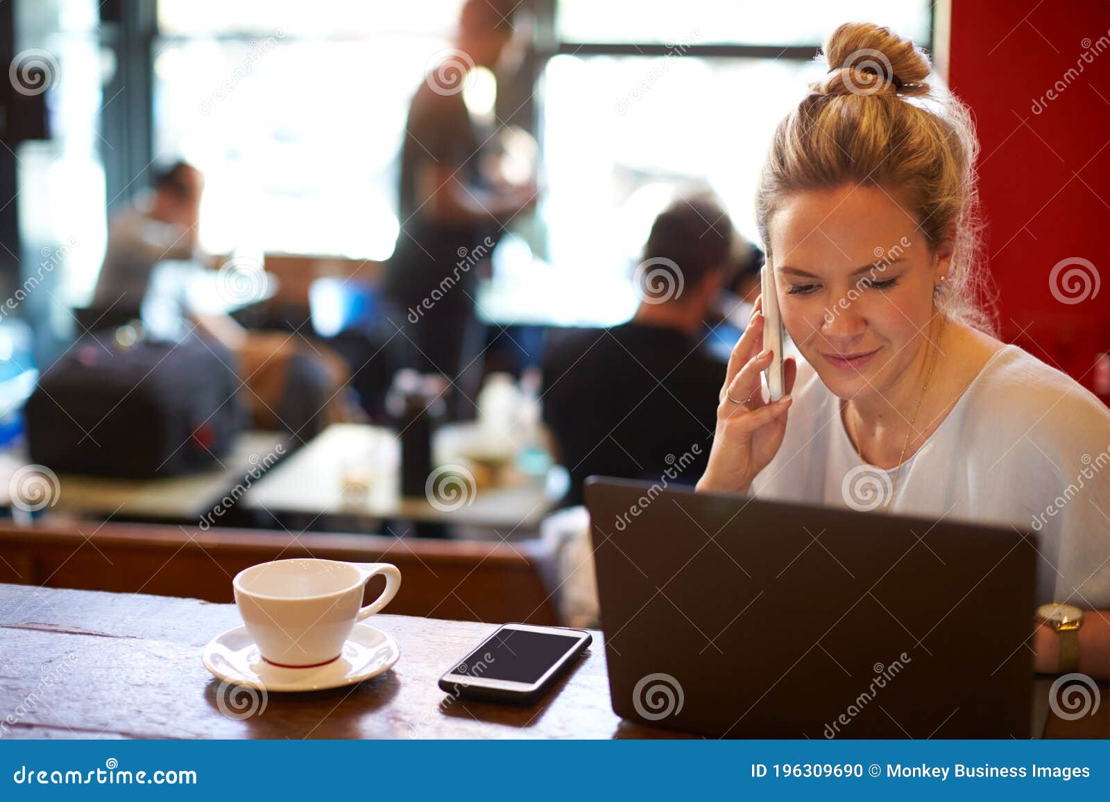 Mujer En Cafetería Trabajando En Laptop Y Usando Teléfono Móvil Foto de  archivo - Imagen de treinta, café: 196309690