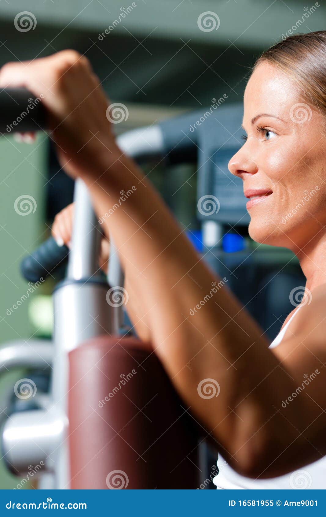 Mujer en gimnasia en el ejercicio de la máquina. Mujer que hace el entrenamiento de la aptitud en una máquina de la mariposa con los pesos en una gimnasia