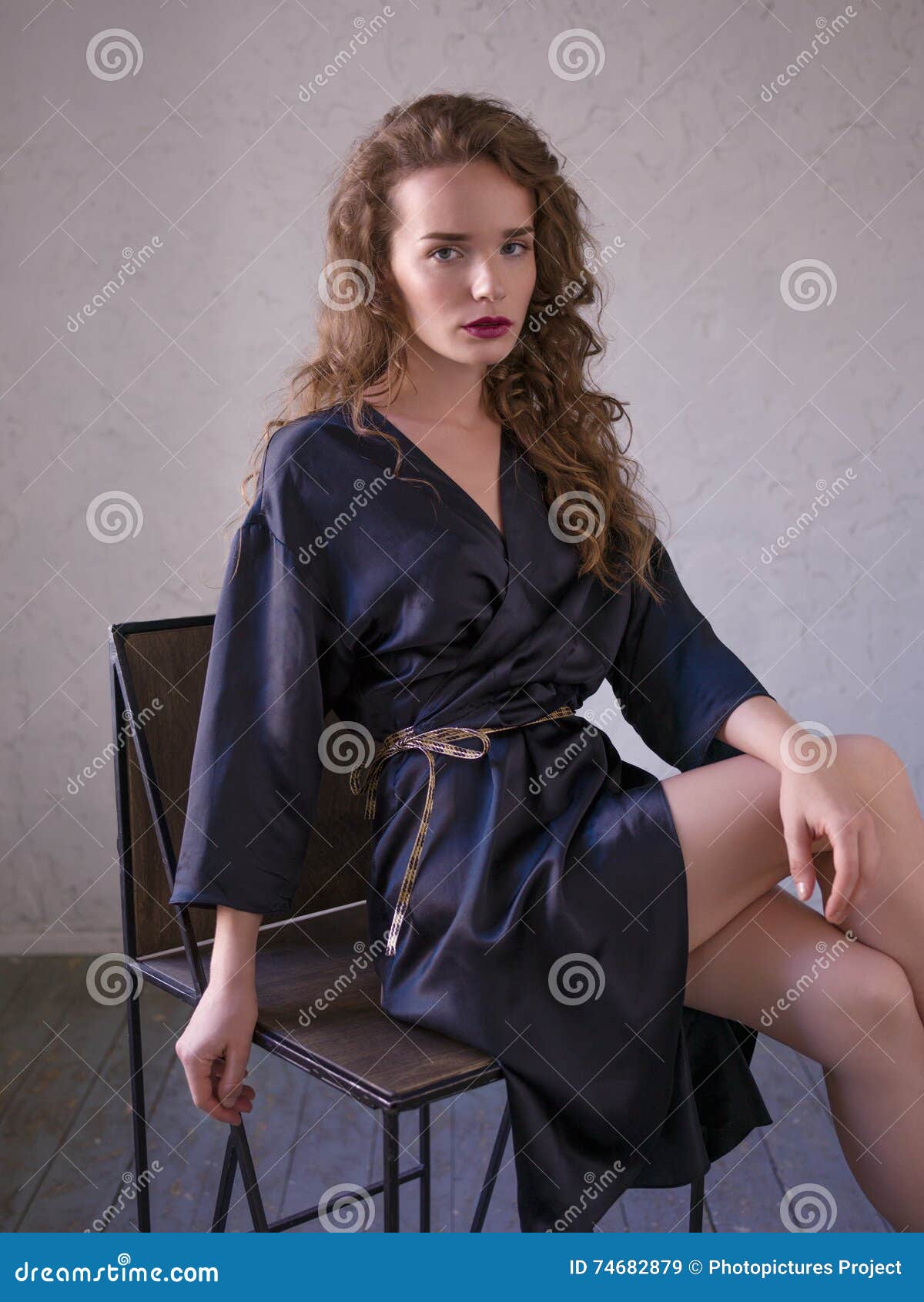 Mujer En La Albornoz De Seda Que Se Sienta En Una Silla Imagen archivo - Imagen de piernas, joven: 74682879