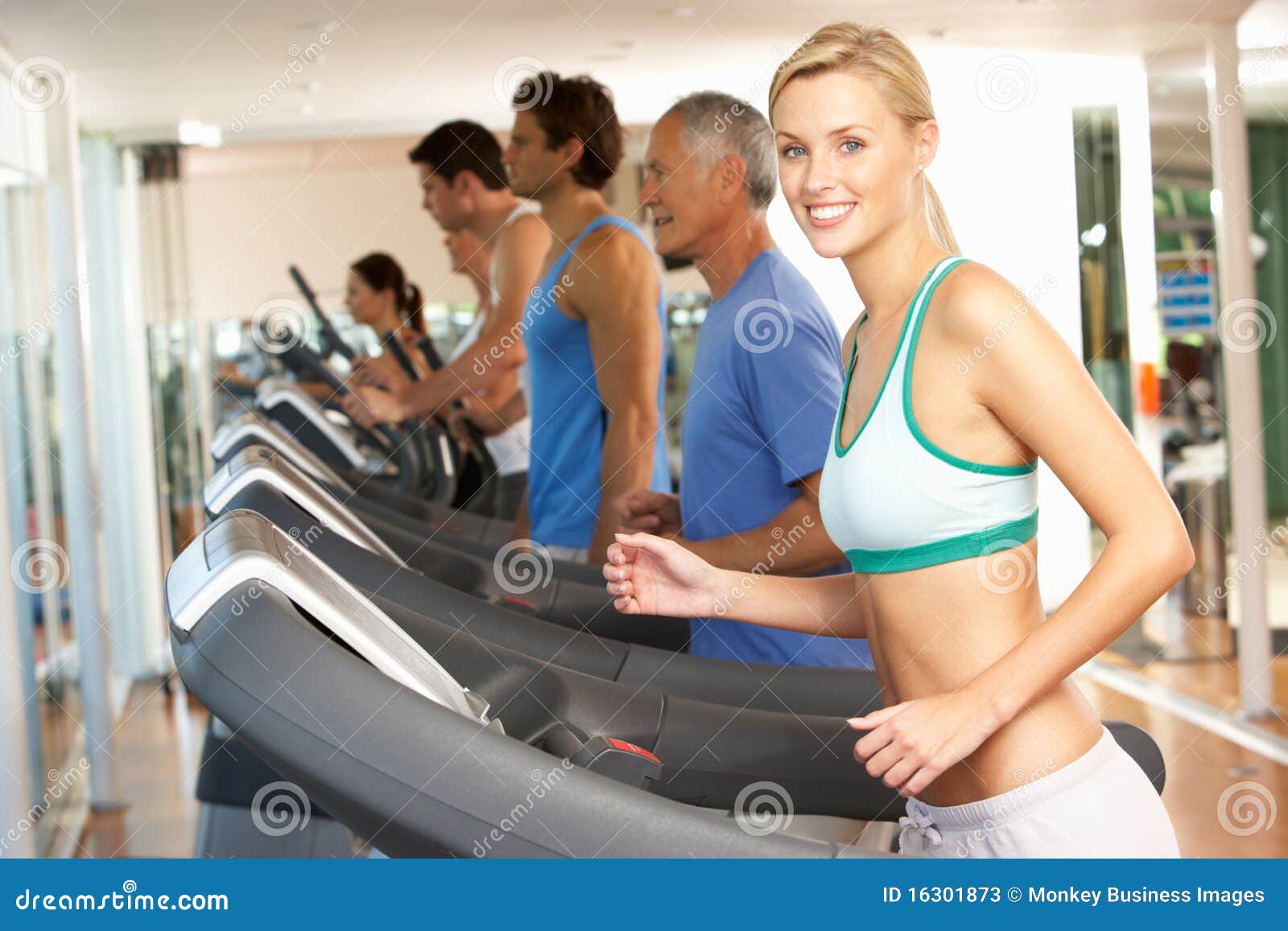 Mujer en la máquina corriente en gimnasia