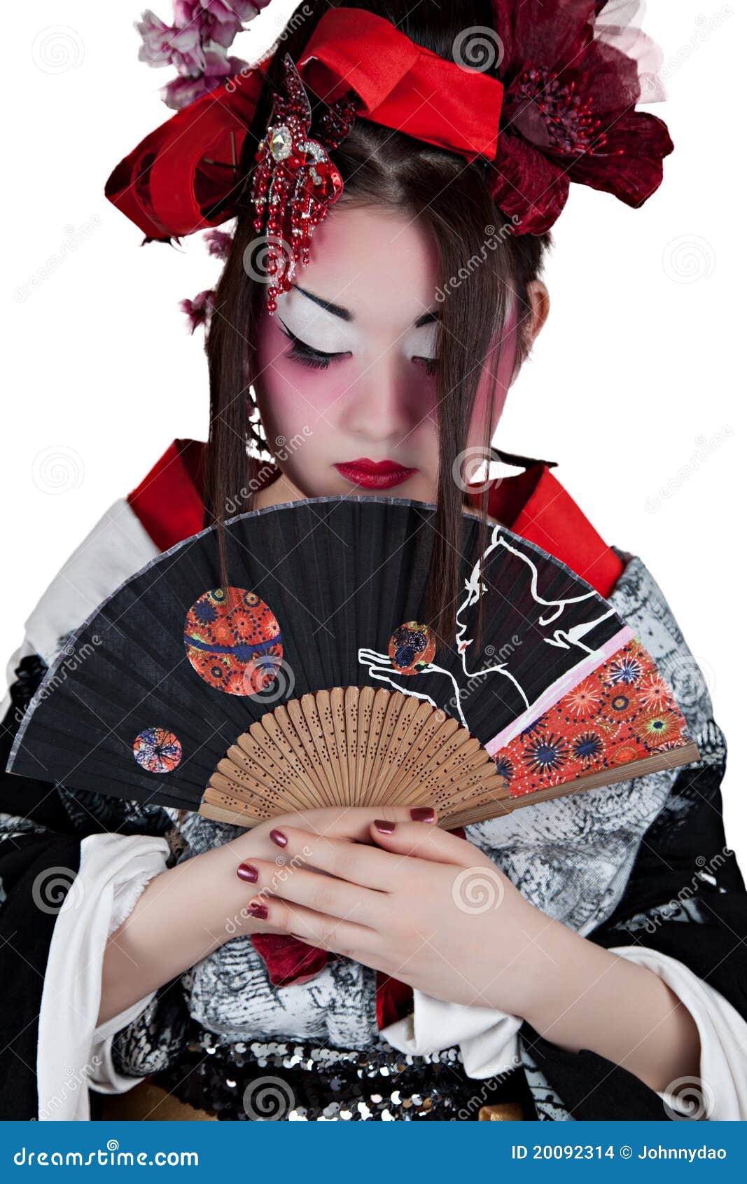 Mujer en un kimono japonés. Mujer asiática hermosa que desgasta un kimono japonés que sostiene un ventilador plegable aislado en el fondo blanco