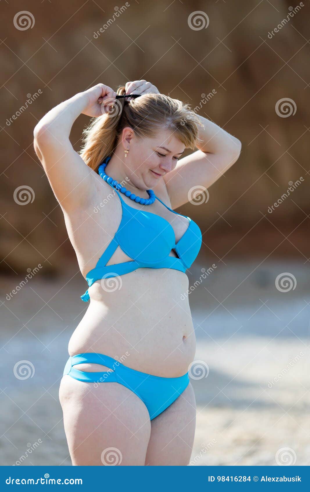 Mujer Gorda En El Bikini Azul Que Ajusta Su Peinado En Seash Foto de  archivo - Imagen de sano, moderno: 98416284