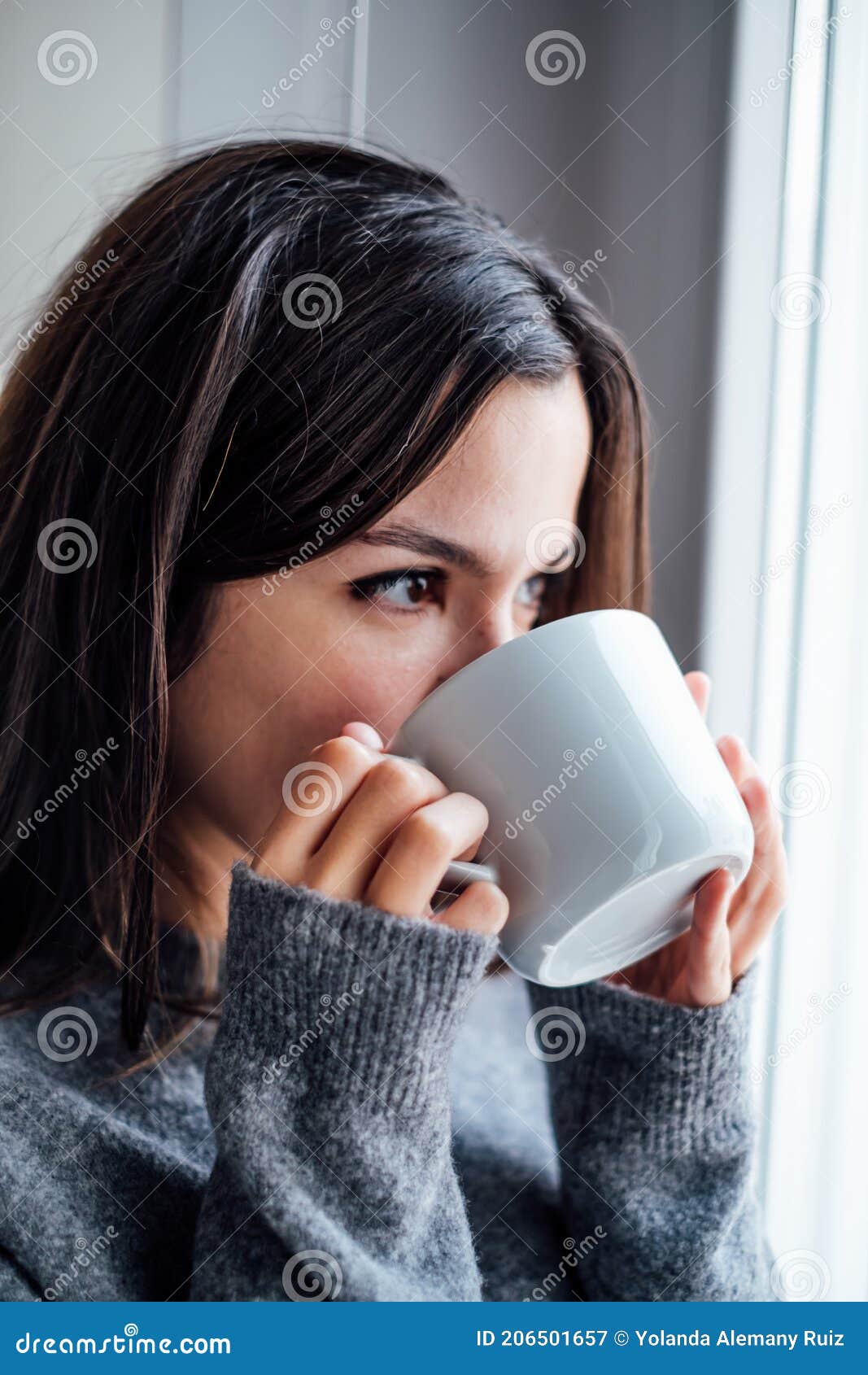 Mujer Guapa Tomando Café De Una Taza Blanca Y Mirando Por La Ventana Imagen De Archivo Imagen