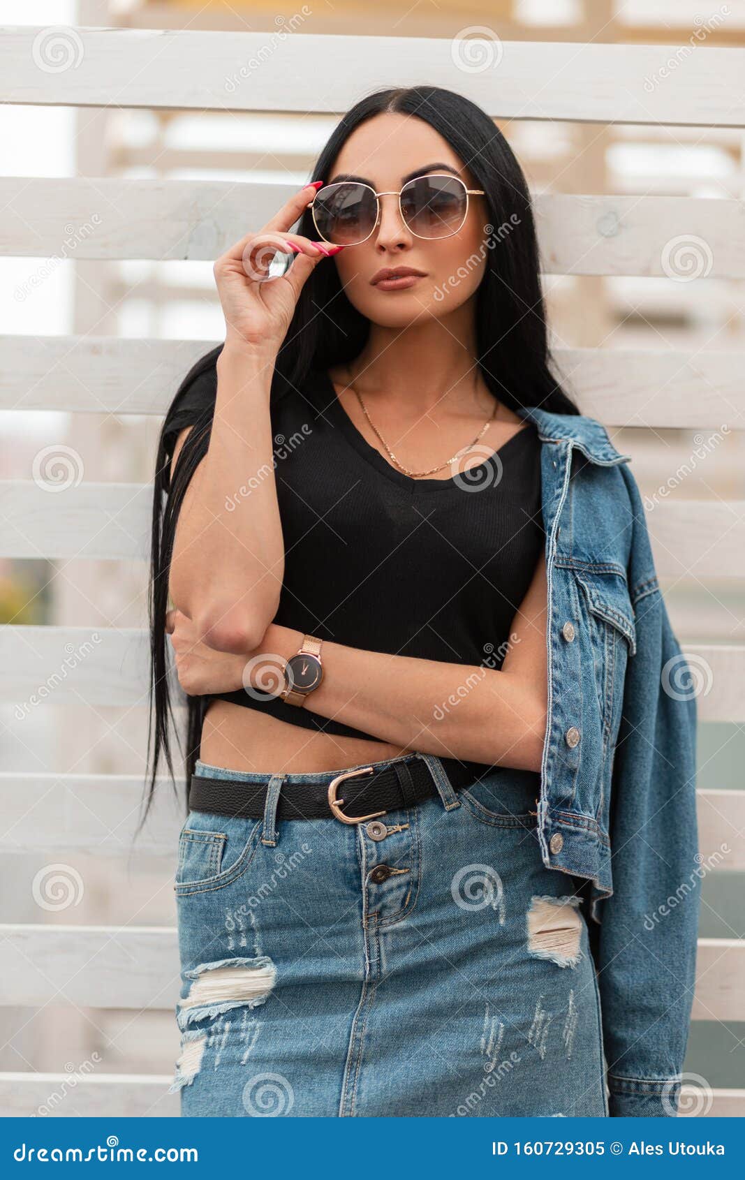 Mujer Hipster Muy Sexy En Una Falda Una Chaqueta De Moda Denim Se Pone Y Endereza Las Elegantes Gafas Negras De Sol Imagen de - Imagen muchacha, pelo: 160729305