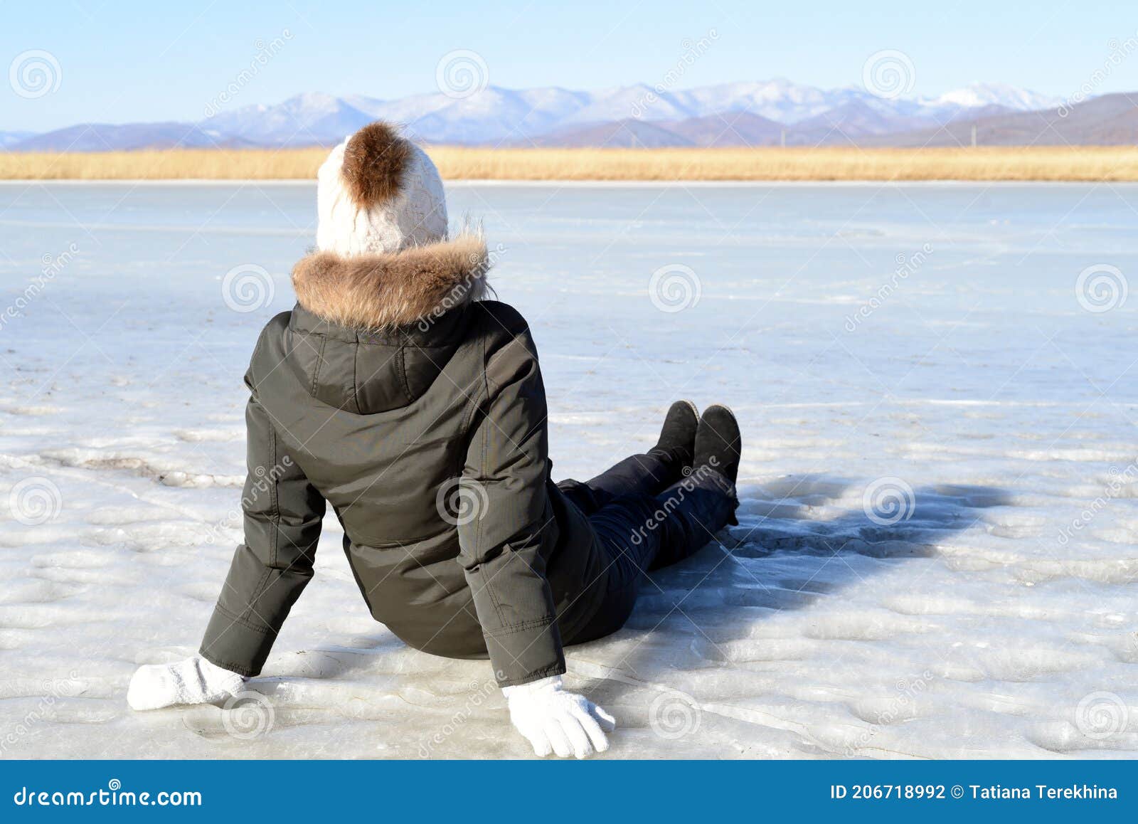 Mujer Joven Con Ropa Abrigada Sentada En El Hielo Y Mirando