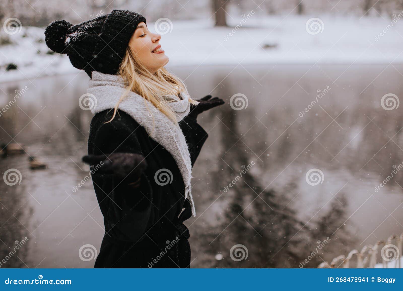 Mujer Joven Con Ropa De Abrigo Disfrutando De La Nieve Imagen de