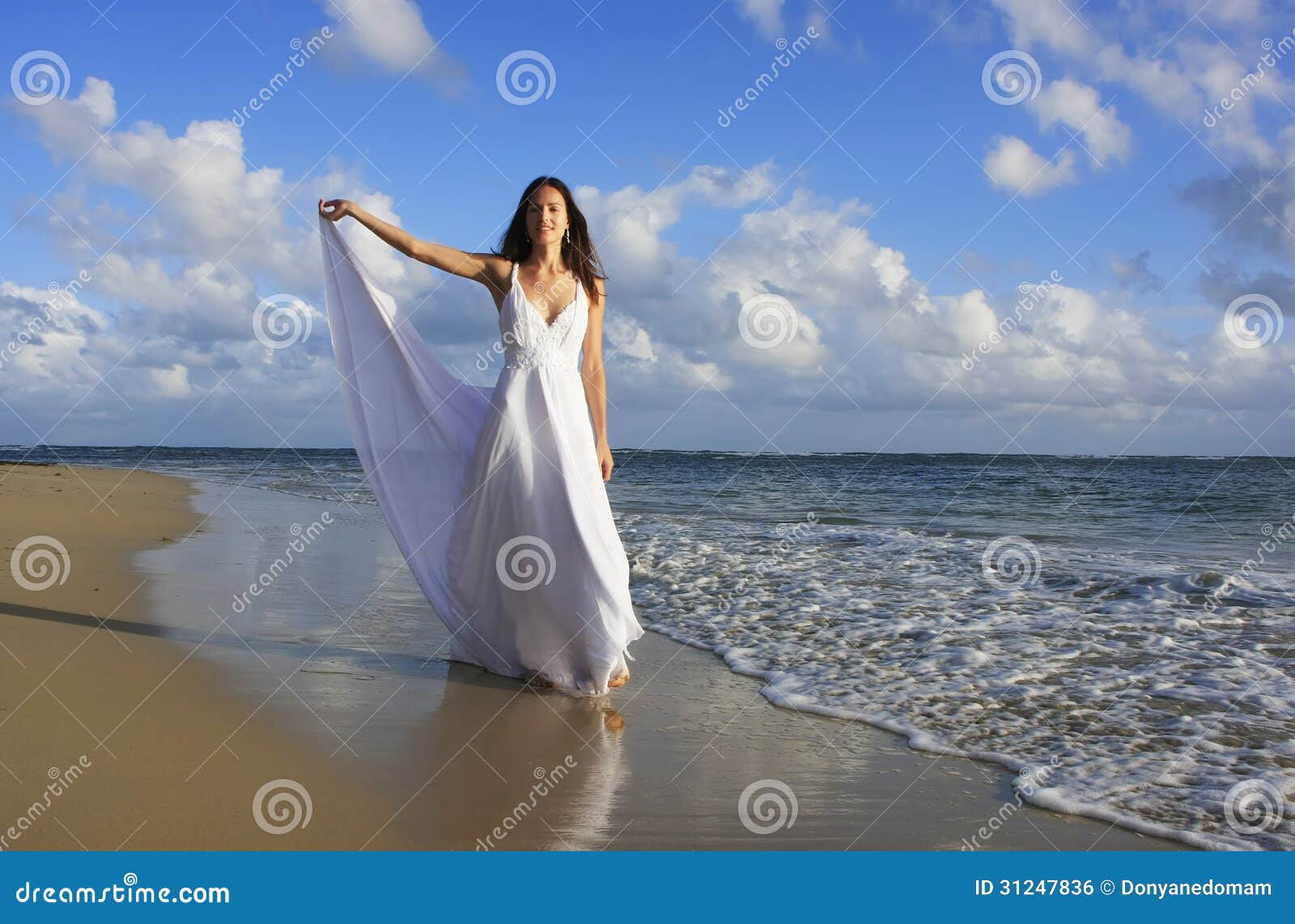 Mujer con vestido blanco en la playa.