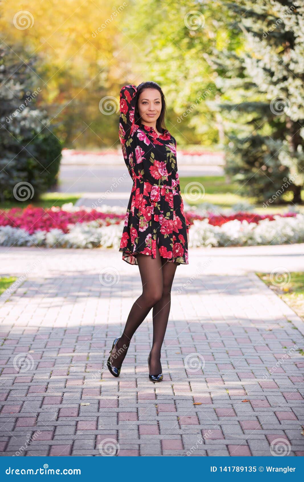 Mujer Joven Feliz De La Moda En Vestido De Flores En Parque De La Ciudad  Imagen de archivo - Imagen de afuera, floral: 141789135