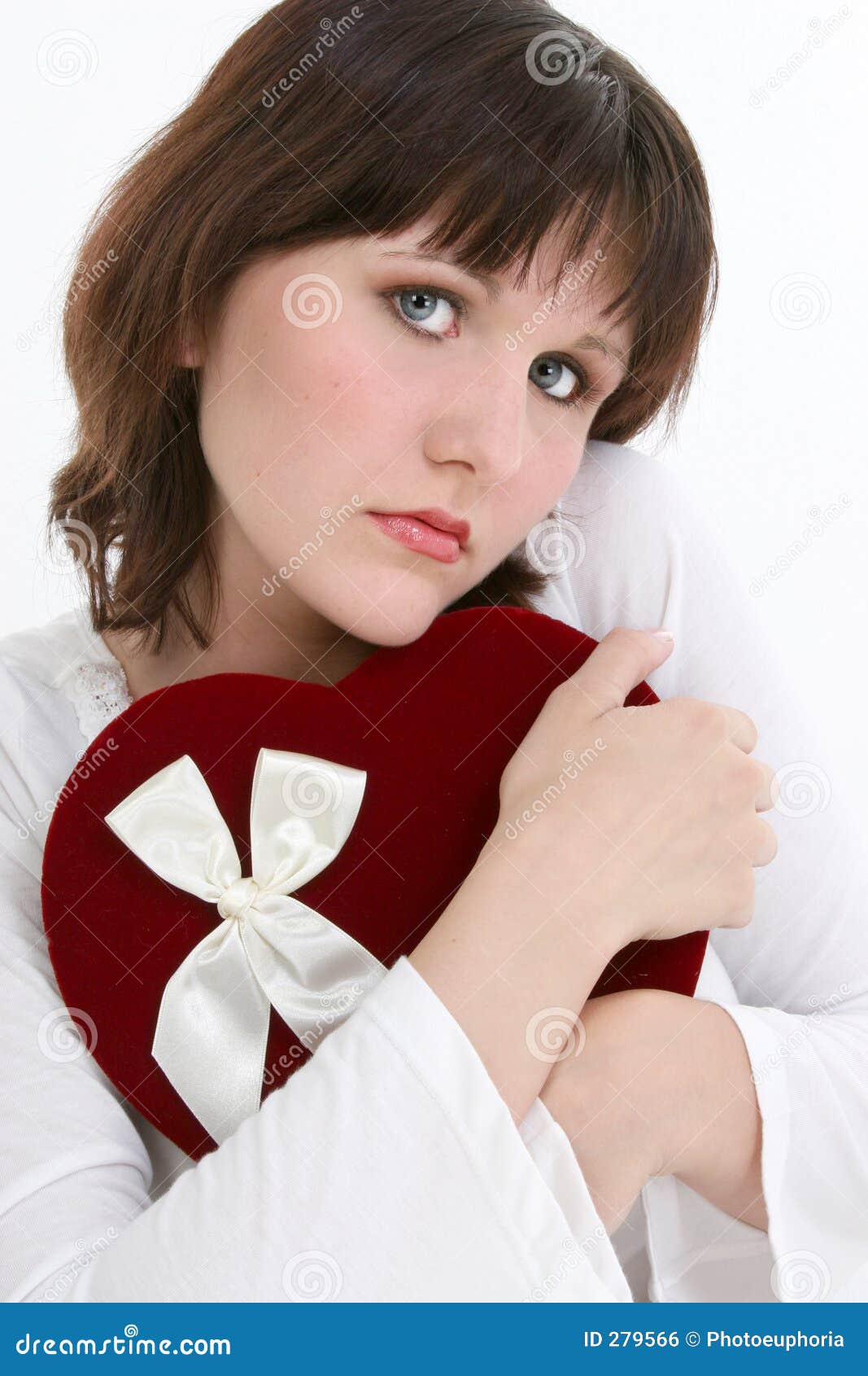 Mujer joven hermosa que piensa en su tarjeta del día de San Valentín