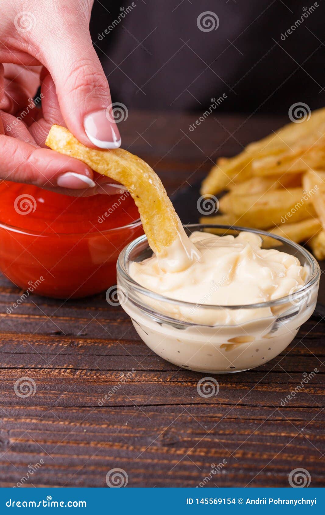 Mujer Joven Moja Papas Fritas a La Salsa Mayonesa Foto de archivo