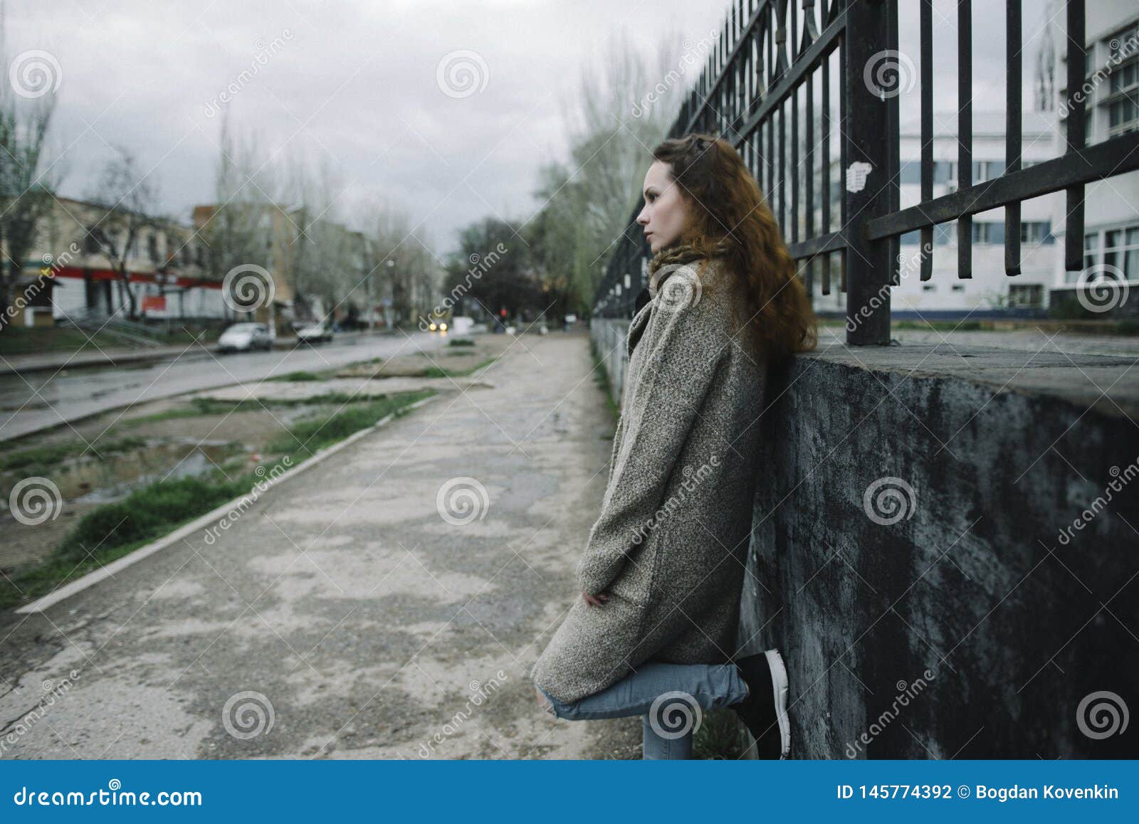 Mujer joven que presenta en la calle en una rebeca marr?n en la foto