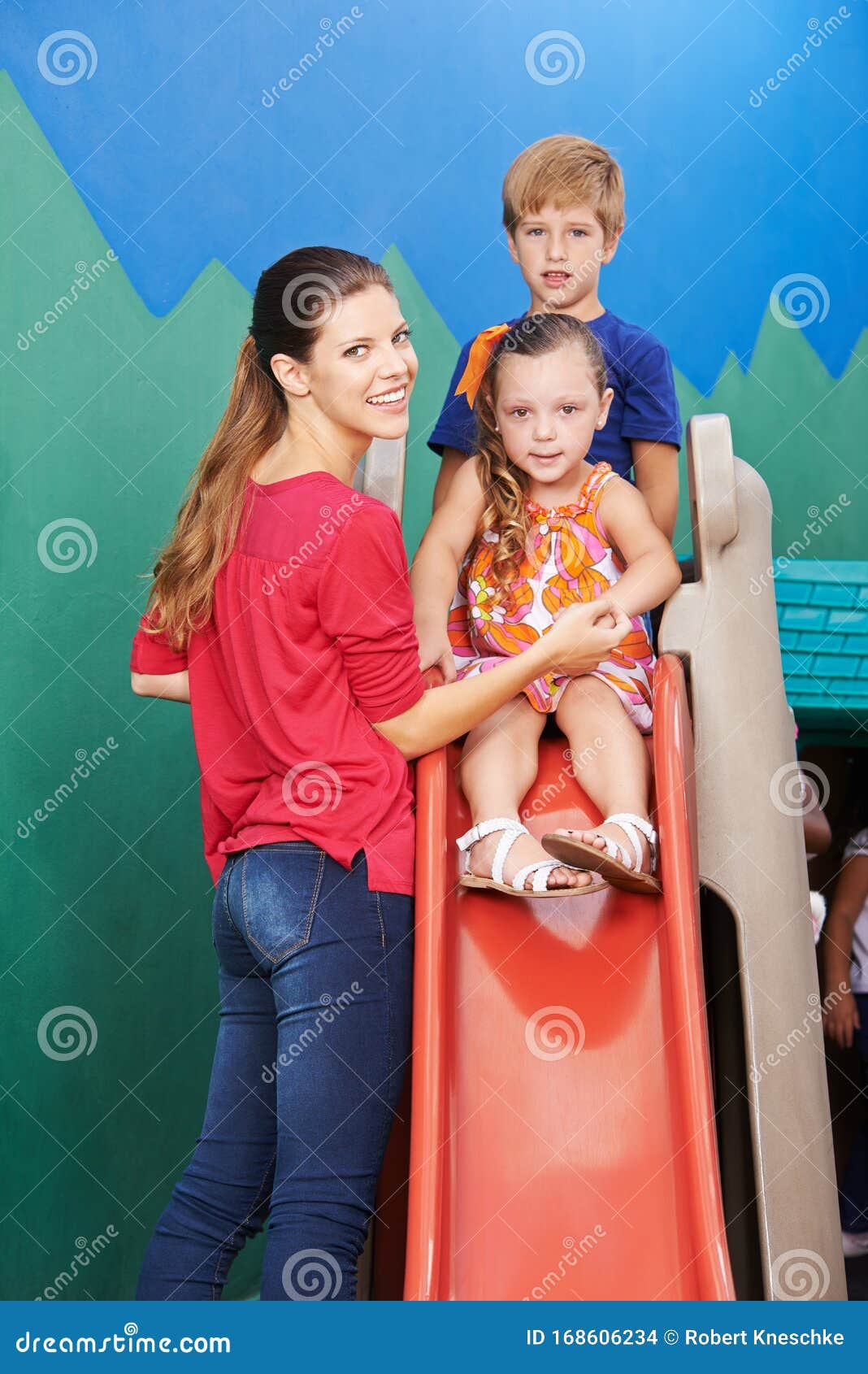 Mujer Junto A Los Niños En Un Tobogán En Un Jardín De Infantes Foto de archivo - Imagen de junto, tobogán: 168606234