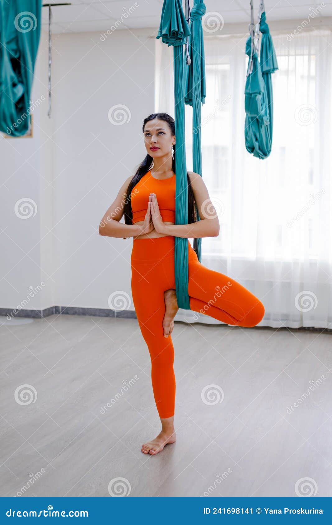 Mujer Morena De 25 Años Colgando Con Hamaca Para El Yoga. Señora Con Ropa  Deportiva Naranja Imagen de archivo - Imagen de coloque, deporte: 241698141
