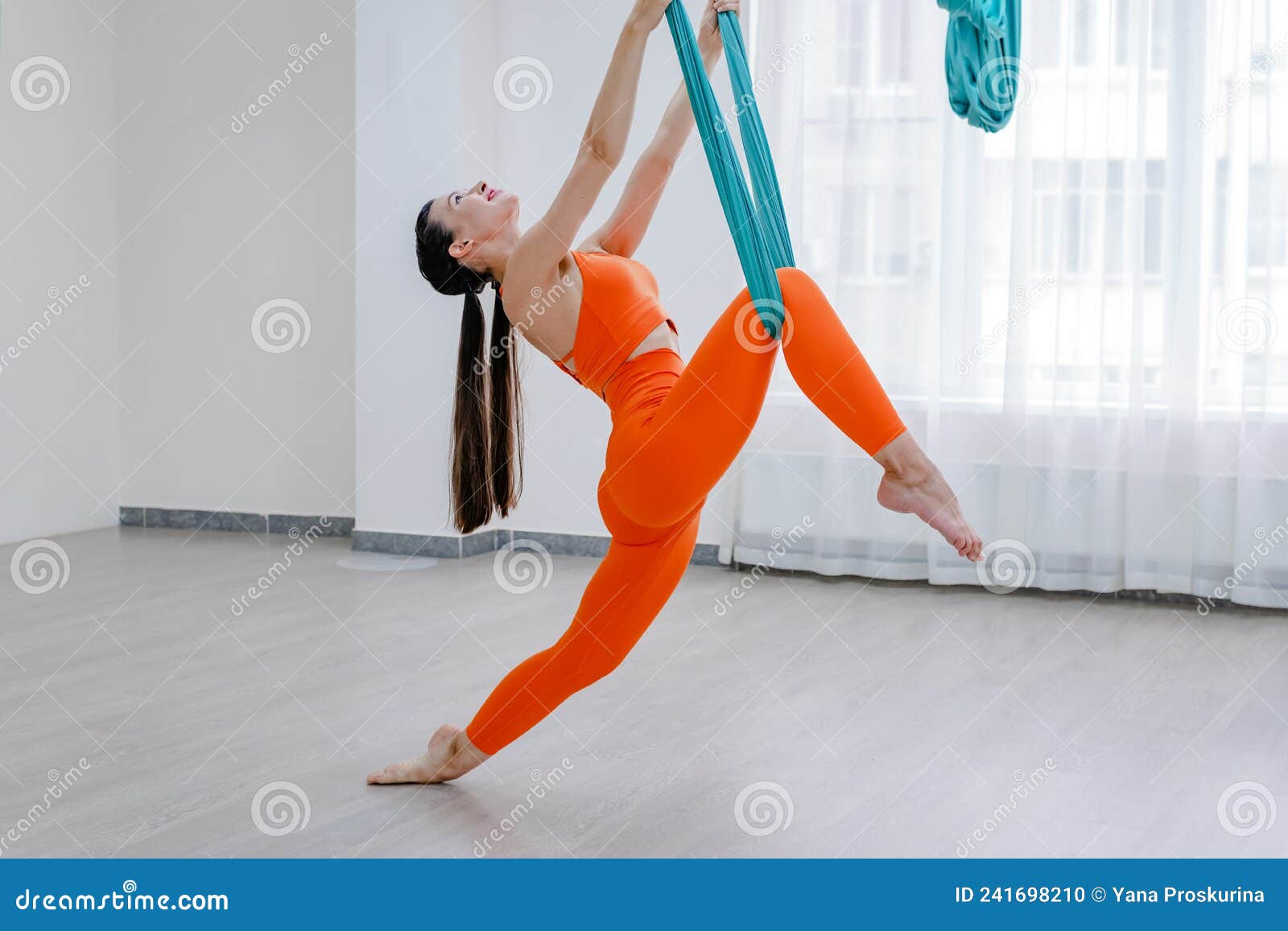 Mujer Morena De 25 Años Colgando Con Hamaca Para El Yoga. Señora Con Ropa  Deportiva Naranja Foto de archivo - Imagen de entrenamiento, flexible:  241698210