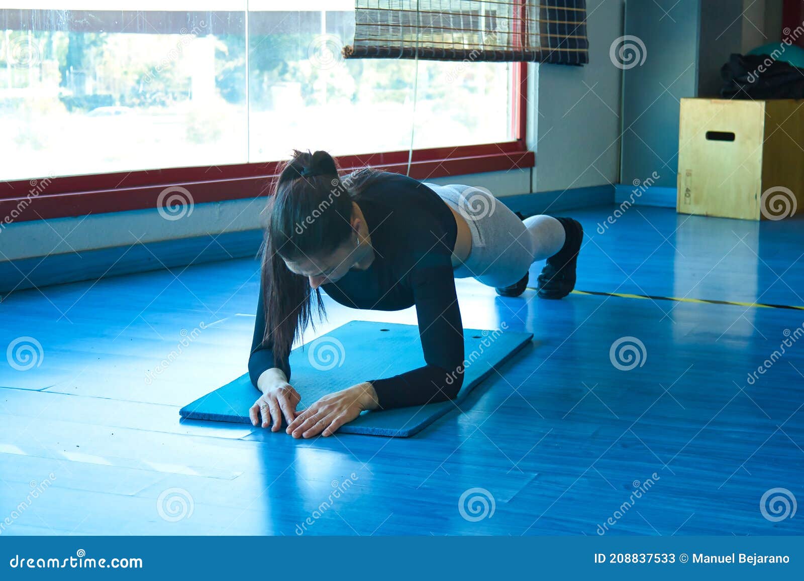 mujer morena haciendo tablÃÂ³n abdominal en el gimnasio
