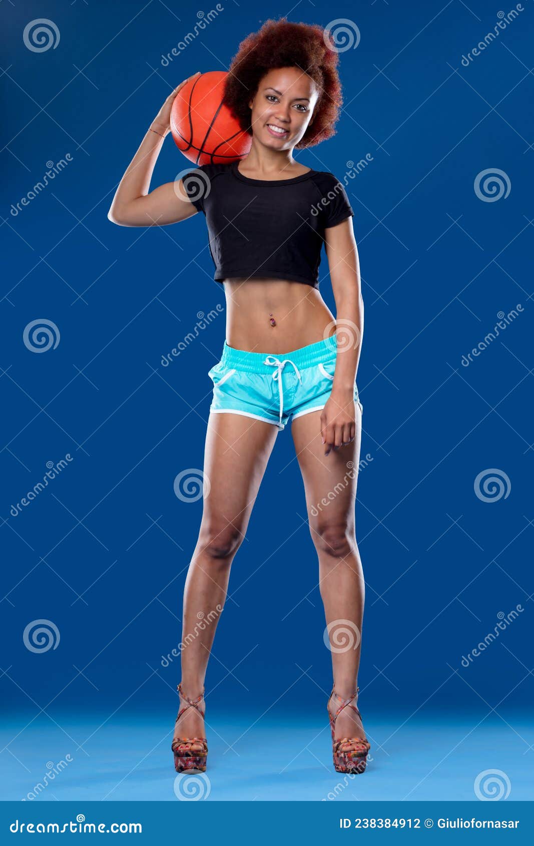 Ropa deportiva de mujer en azul en una hermosa modelo delgada deportista  posando en el gimnasio pantalones cortos y top azules