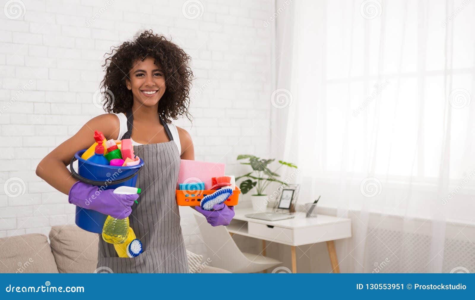 Mujer Negra Sonriente Que Presenta Con Las Fuentes De Limpieza Imagen De Archivo Imagen De