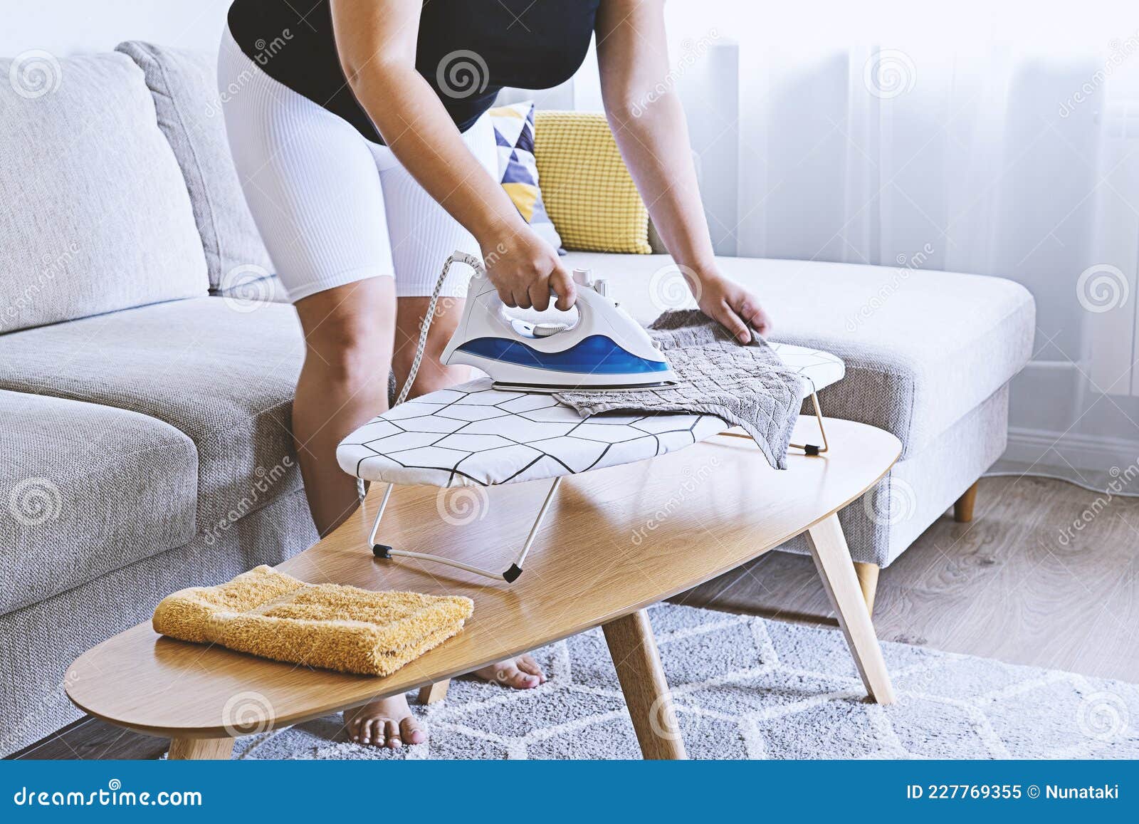 Mujer Planchando En Una Pequeña Tabla De Planchar En Una Sala De Estar  Clara Imagen de archivo - Imagen de lavadero, apartamentos: 227769355