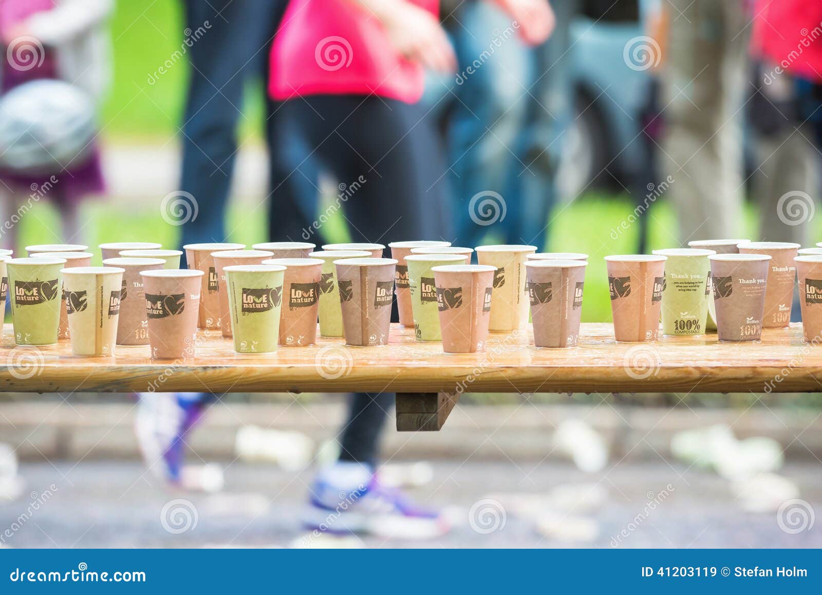 ESTOCOLMO - 31 DE MAYO: Mujer que pasa la estación del agua con las tazas en fila en el maratón 2014 de ASICS Estocolmo 31 de mayo de 2014 en Estocolmo, Suecia