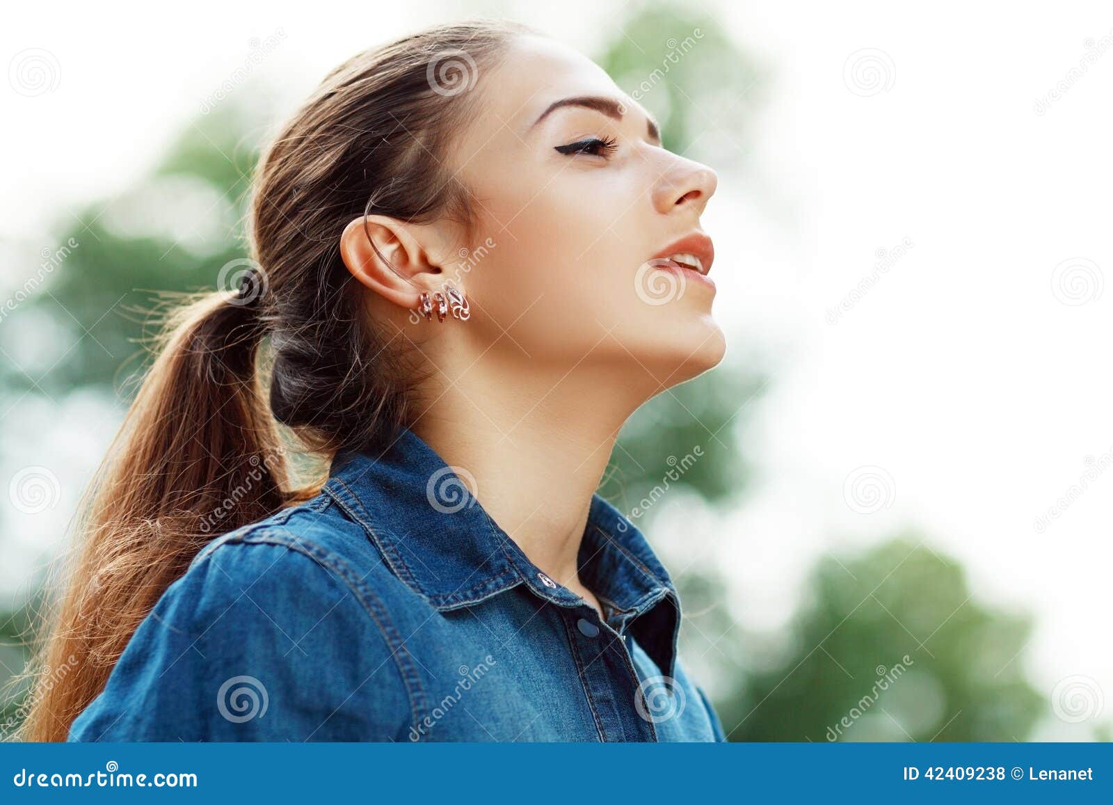 Mujer que respira el aire fresco. Mujer atractiva joven que respira el aire fresco al aire libre que muestra su cara al viento