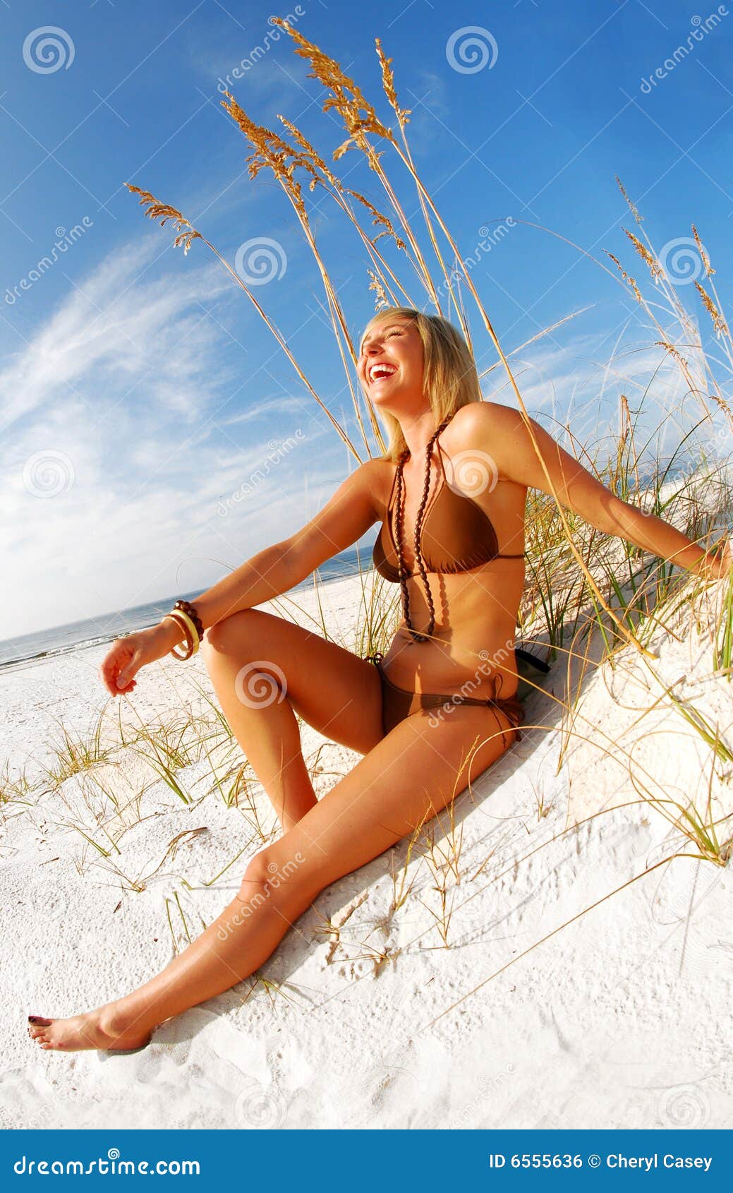 Mujer que ríe en la playa. Mujer bonita en bikiní que ríe en la playa