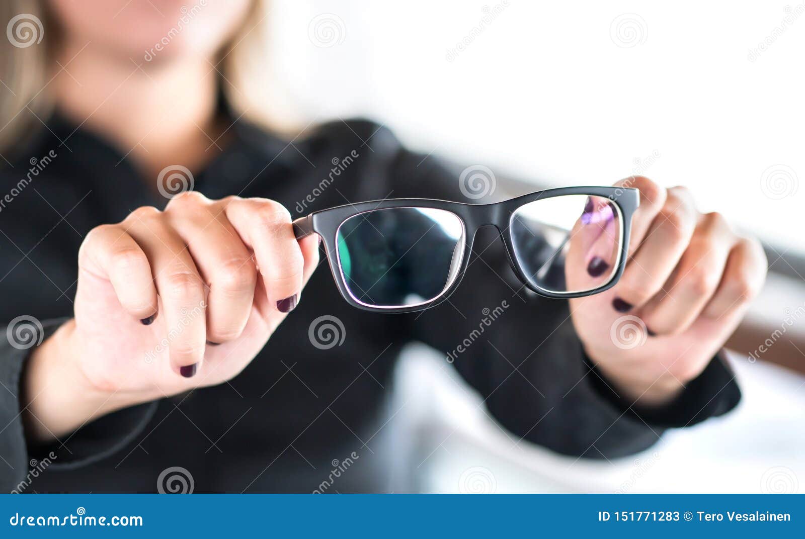 Soporte con gafas en la tienda de óptica la mano de una mujer