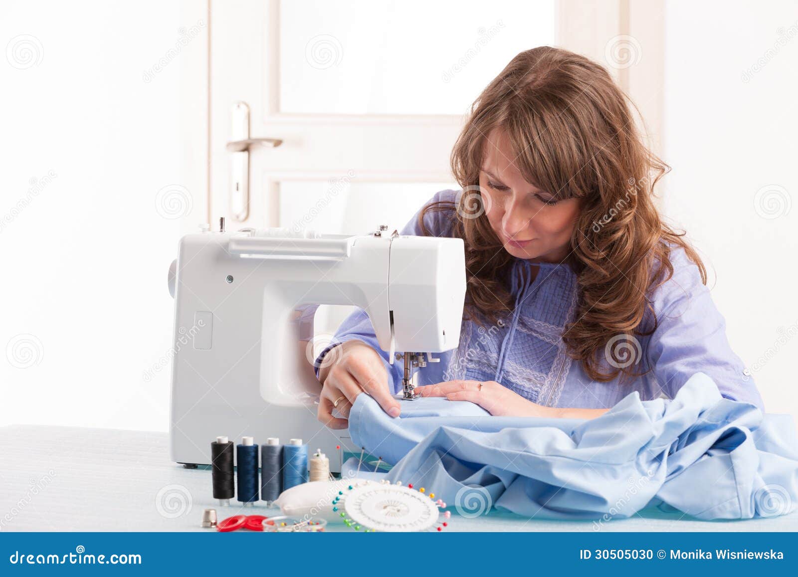 Mujer Que Usa La Máquina De Coser Para Coser La Ropa Imagen de