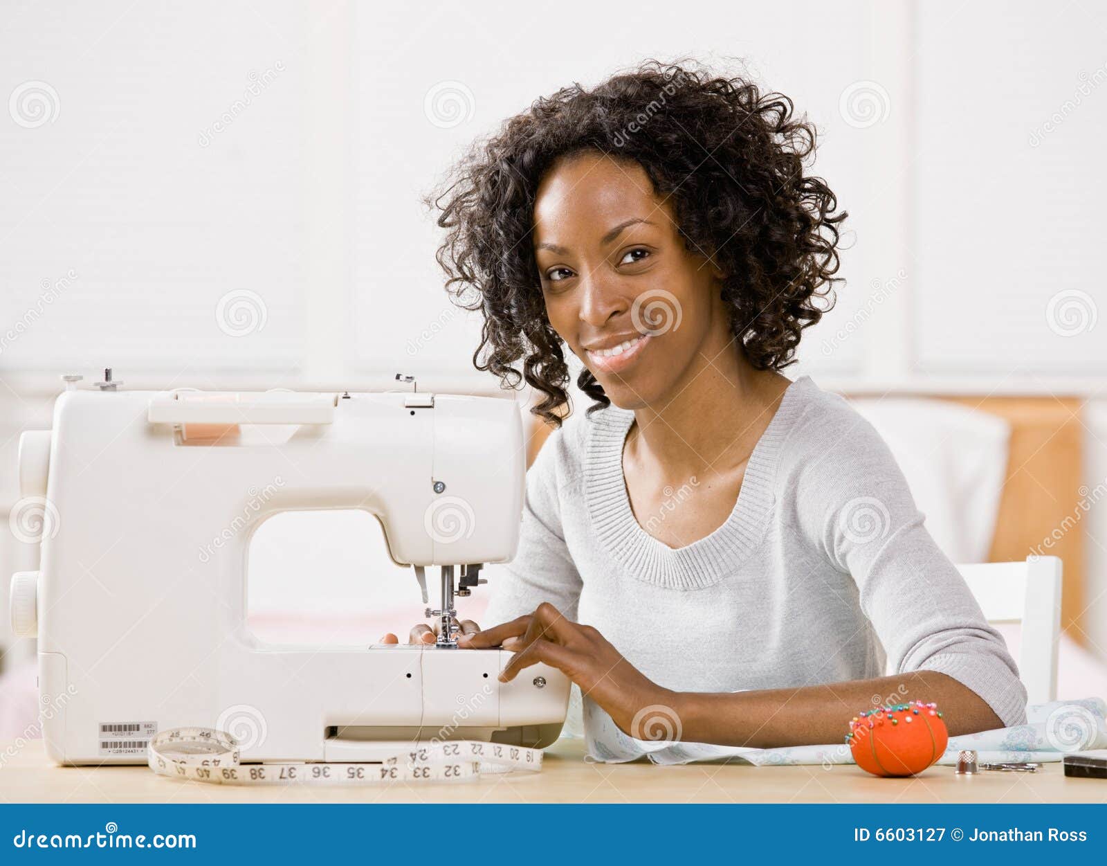 Mujer Que Usa La Máquina De Coser Para Coser La Ropa Imagen de