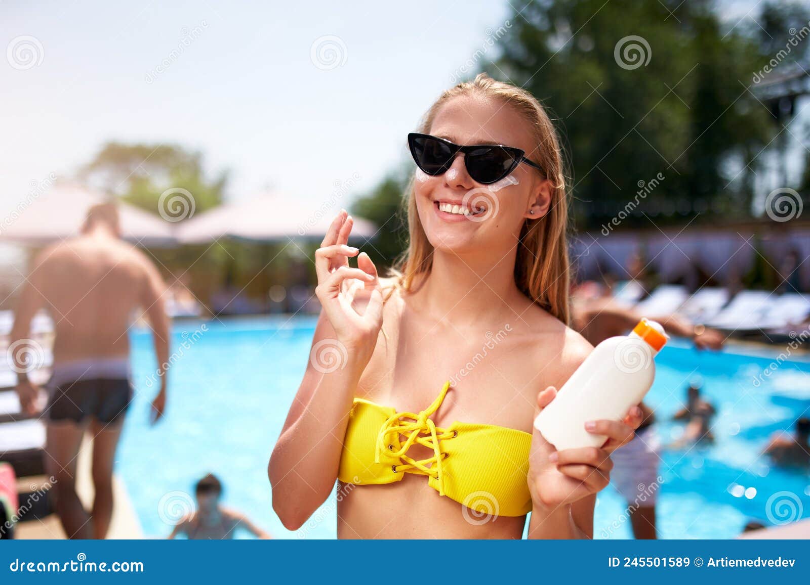 Mujer Rubia Aplica Crema Solar De Protección Solar En Cheeck Y Cara Cerca  De La Piscina. Una Linda Chica Sonriente Pone Crema De S Imagen de archivo  - Imagen de sunbathe, lifestyle: