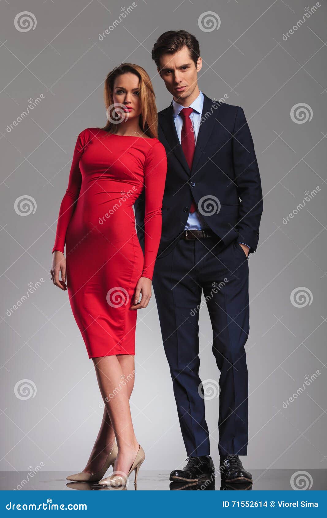 Mujer Rubia Atractiva En El Vestido Rojo Que Se Coloca Al Lado De Hombre De  Negocios Foto de archivo - Imagen de longitud, persona: 71552614