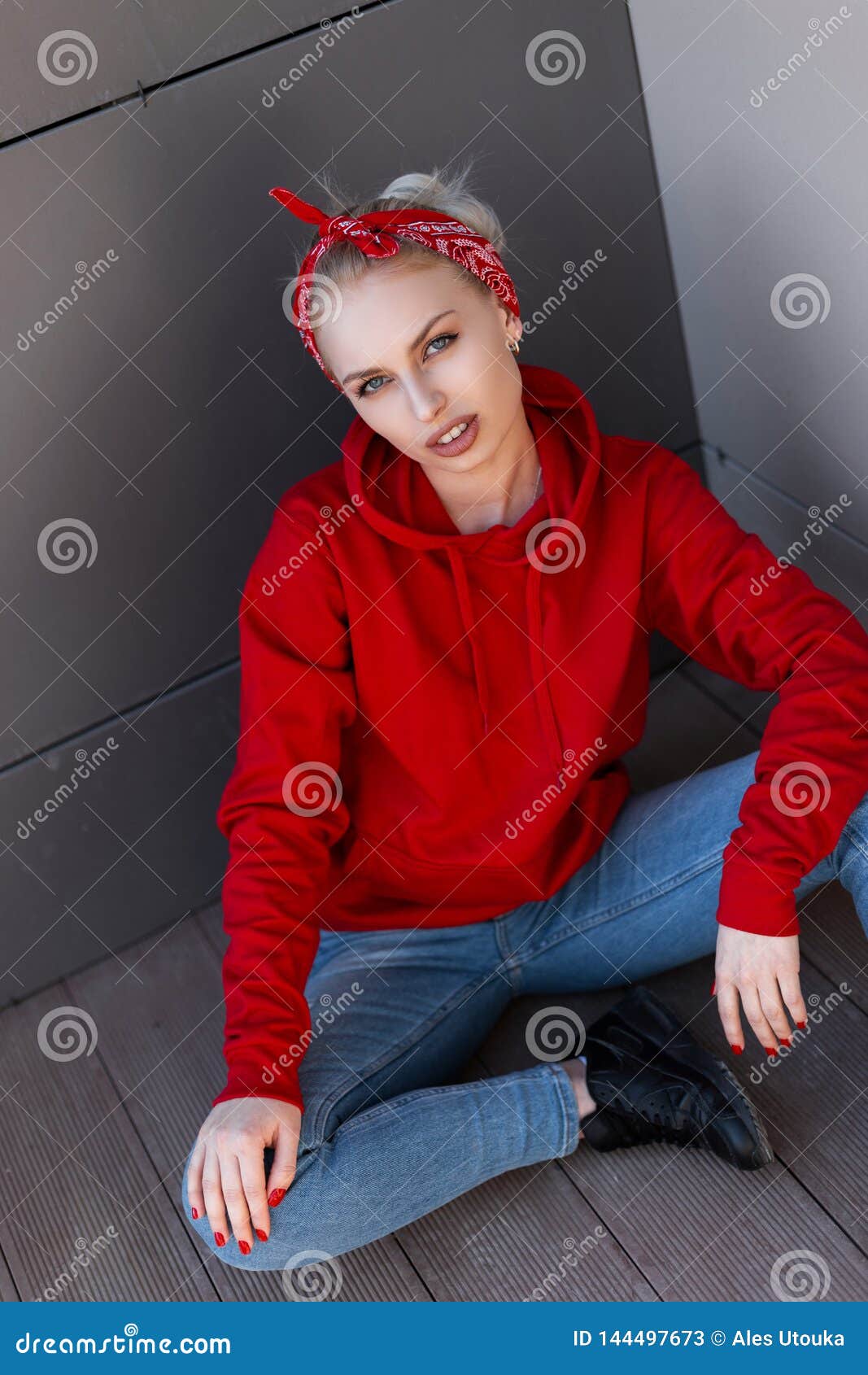 Mujer Rubia Joven Moderna Americana En Una Sudadera Con Capucha Roja De Moda En Pañuelo En Las Botas De Cuero En Tejanos Imagen de archivo - Imagen de fashionable, modelo: 144497673