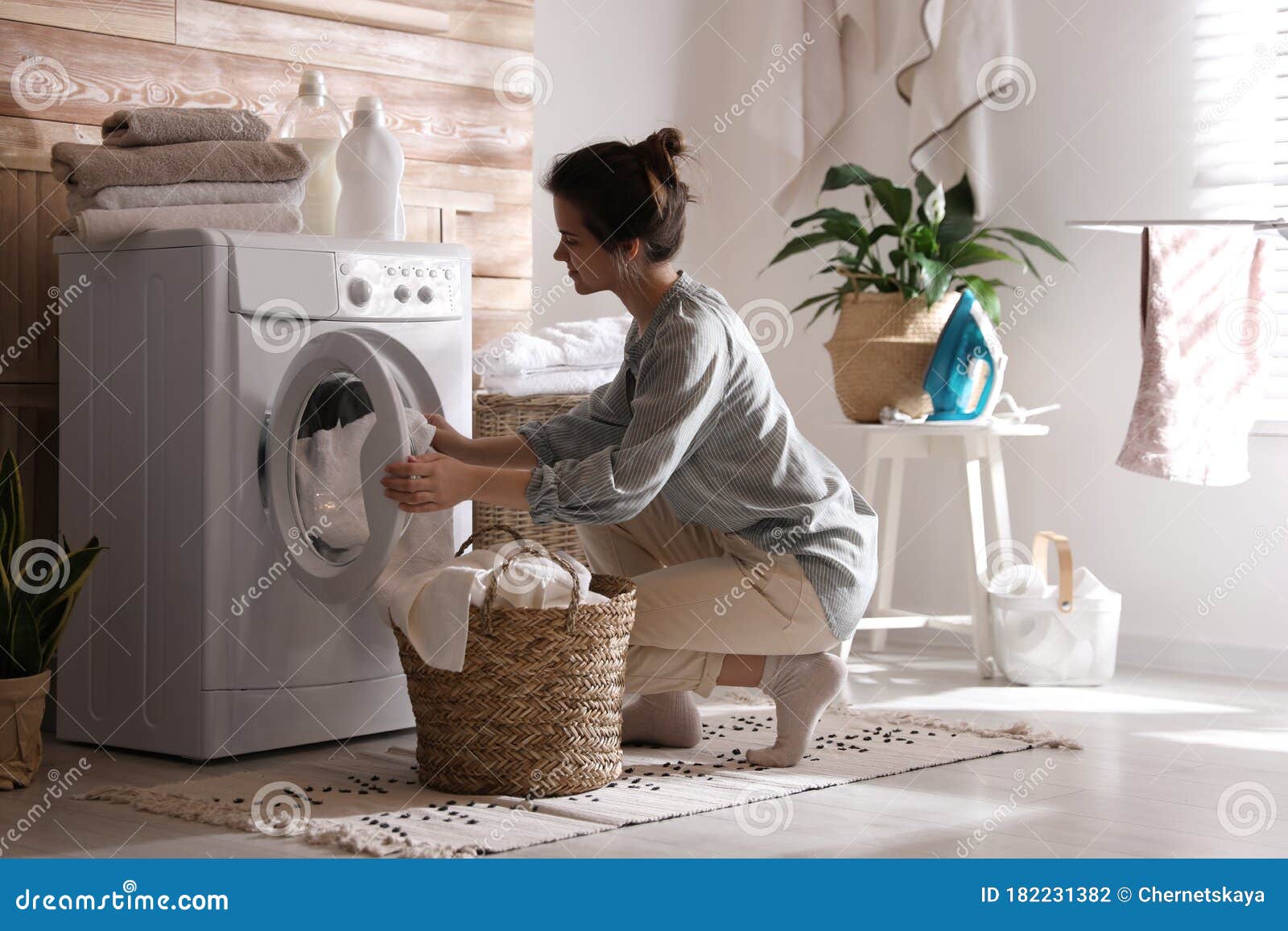 Mujer Sacando La Ropa De La Lavadora En Casa Foto de - Imagen de limpio, lifestyle: 182231382