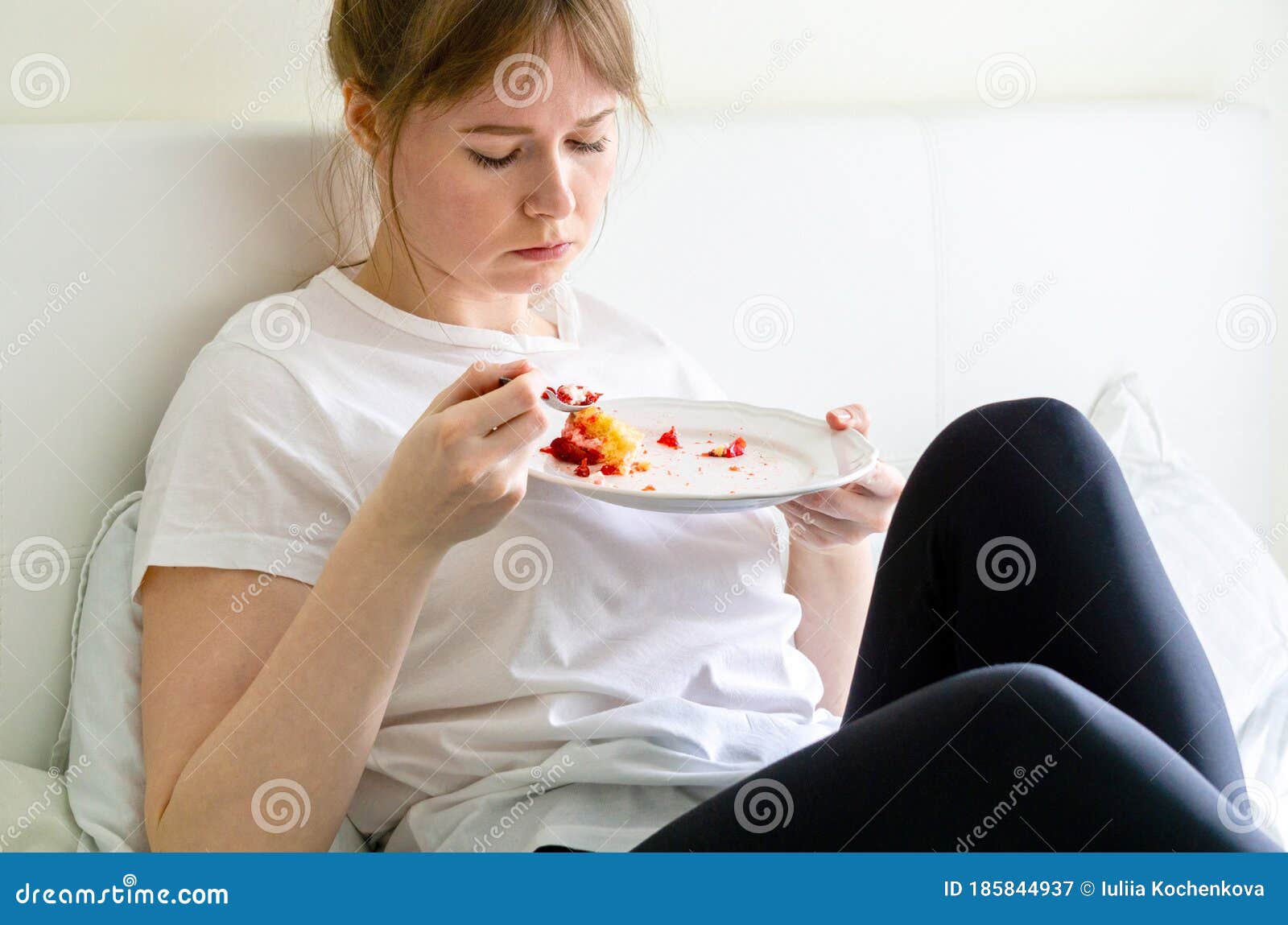 Mujer Sentada En La Cama Y Comiendo Pastel Imagen de archivo - Imagen de  comer, infeliz: 185844937