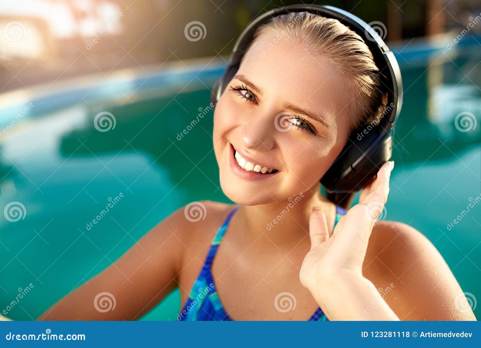 Mujer Sonriente Relajada Que Escucha La Música En Los Auriculares Que Se  Bañan En Piscina La Muchacha Rubia Disfruta De La Canció Foto de archivo -  Imagen de adolescente, control: 123281118