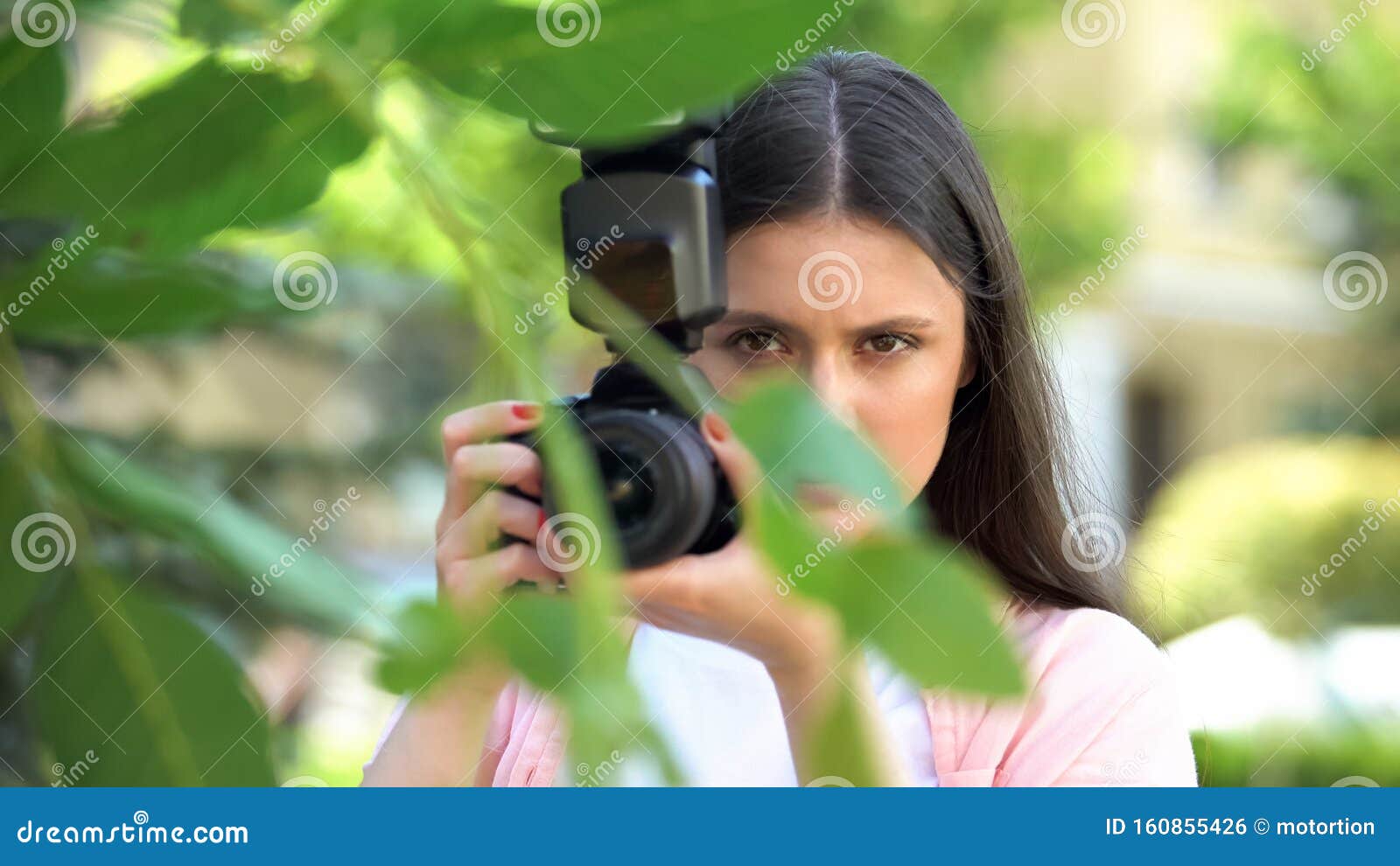 Mujer Sospechosa Con Una Cámara Escondida Detrás De árboles El Parque, Esposo Espía Foto de archivo - de 160855426
