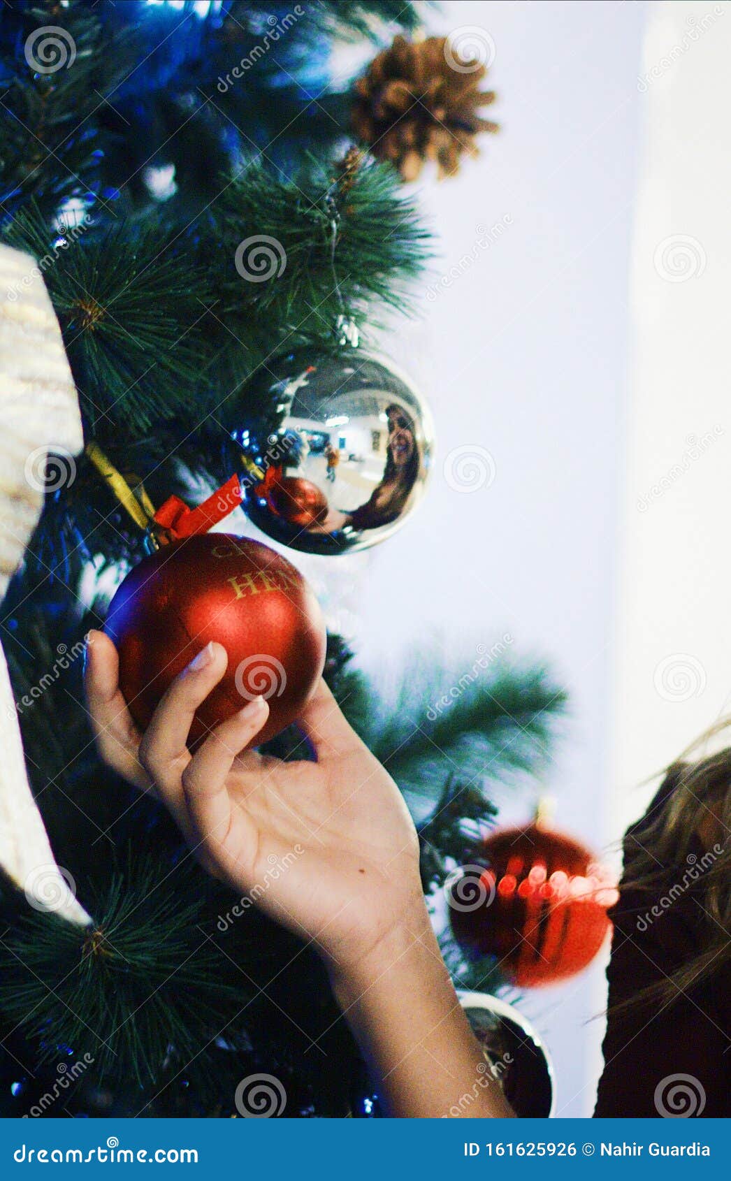 mujer sujetando esfera de arbol de navidad