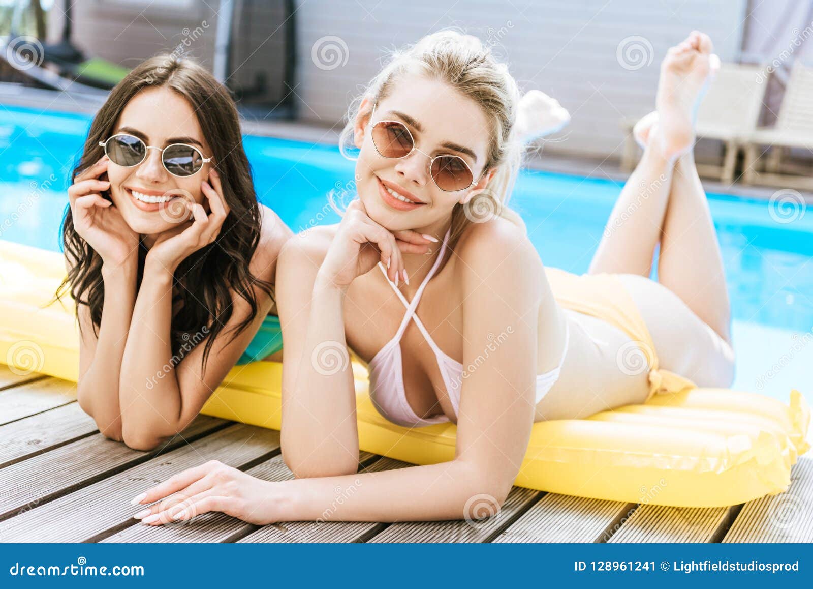Mujeres Jovenes Hermosas En Gafas De Sol Y Traje De Baño Que Miente En El Colchón Inflable Y Que Sonríe En La Cámara Cerca De La Imagen de archivo - Imagen de Mujeres Jovenes Hermosas En Gafas De Sol Y Traje De Baño Que Miente En El Colchón Inflable Y Que Sonríe En La Cámara Cerca De La Imagen de archivo - Imagen de
