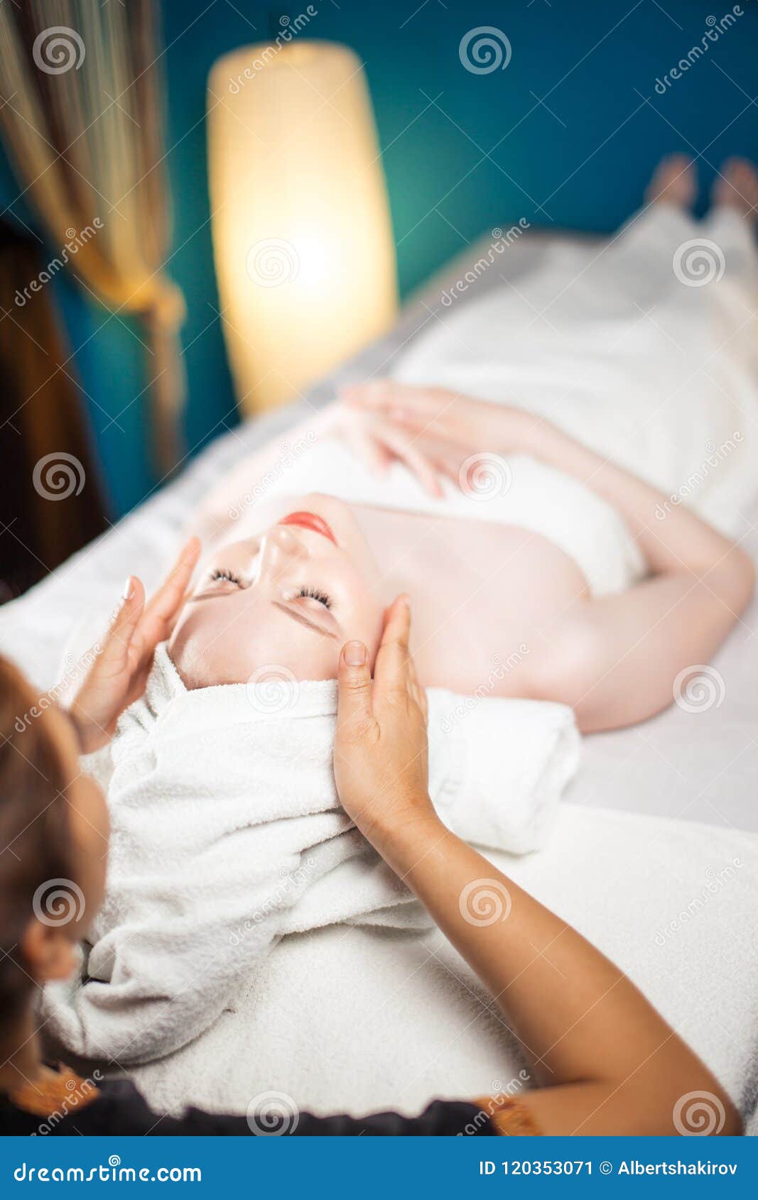 Mulher bonita nova que aprecia o procedimento da massagem de cara. Cara paciente de massagem fêmea do massagista tailandês em termas do bem-estar Acupressure, reflexology