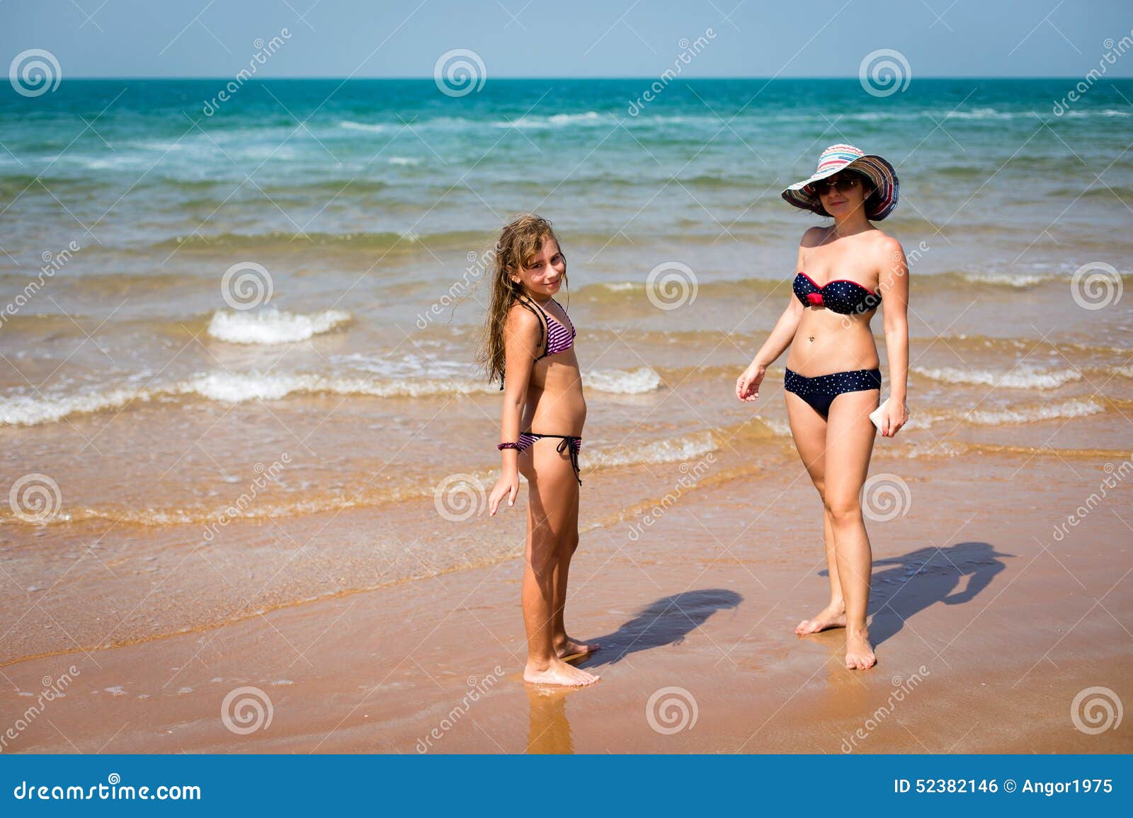 Mulher Bronzeada E Menina Que Estao Na Praia Foto De Stock Imagem De Praia Bronzeada 52382146